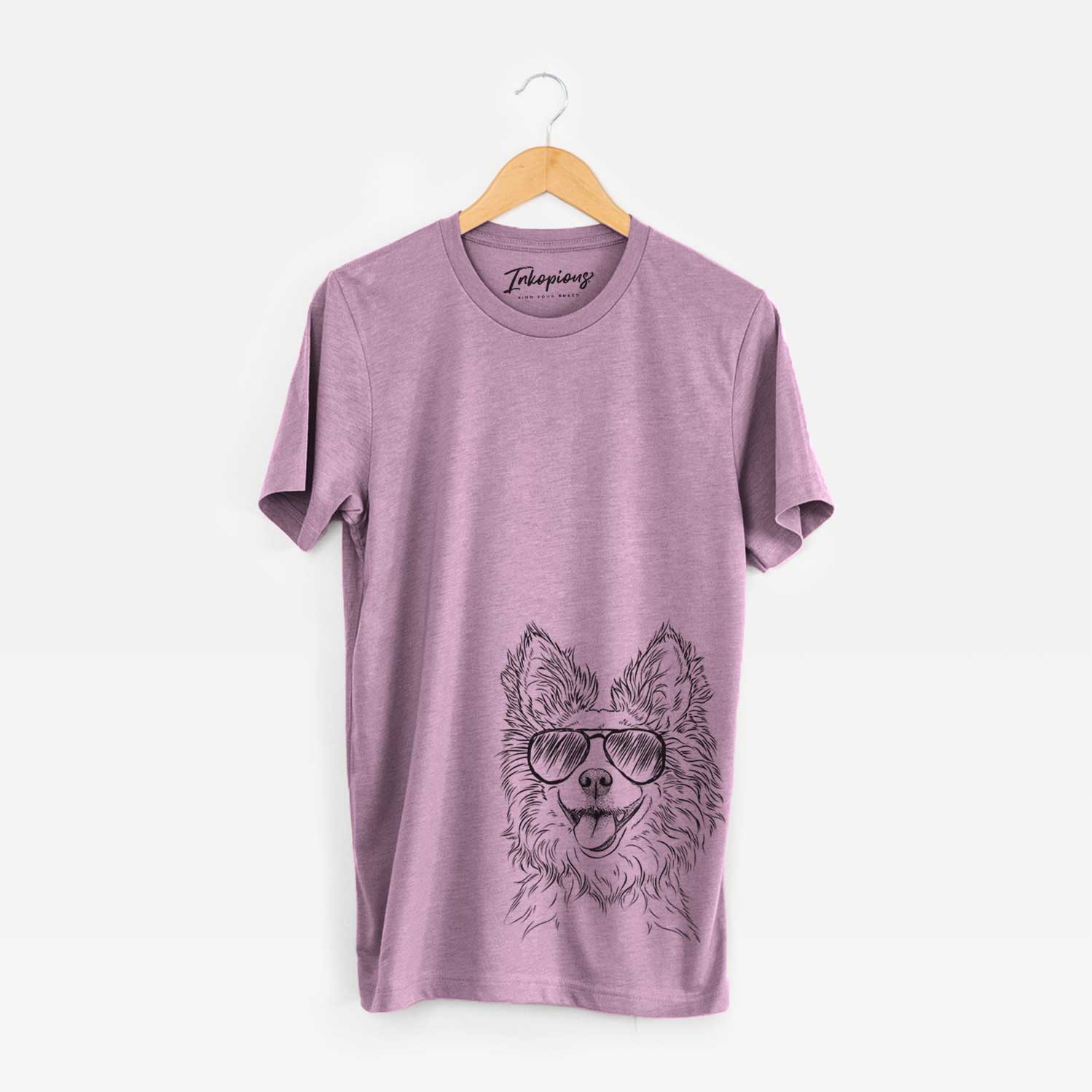 Hand-drawn sketch of Jasper the Pomchi wearing aviator sunglasses on an Orchid Unisex crewneck
