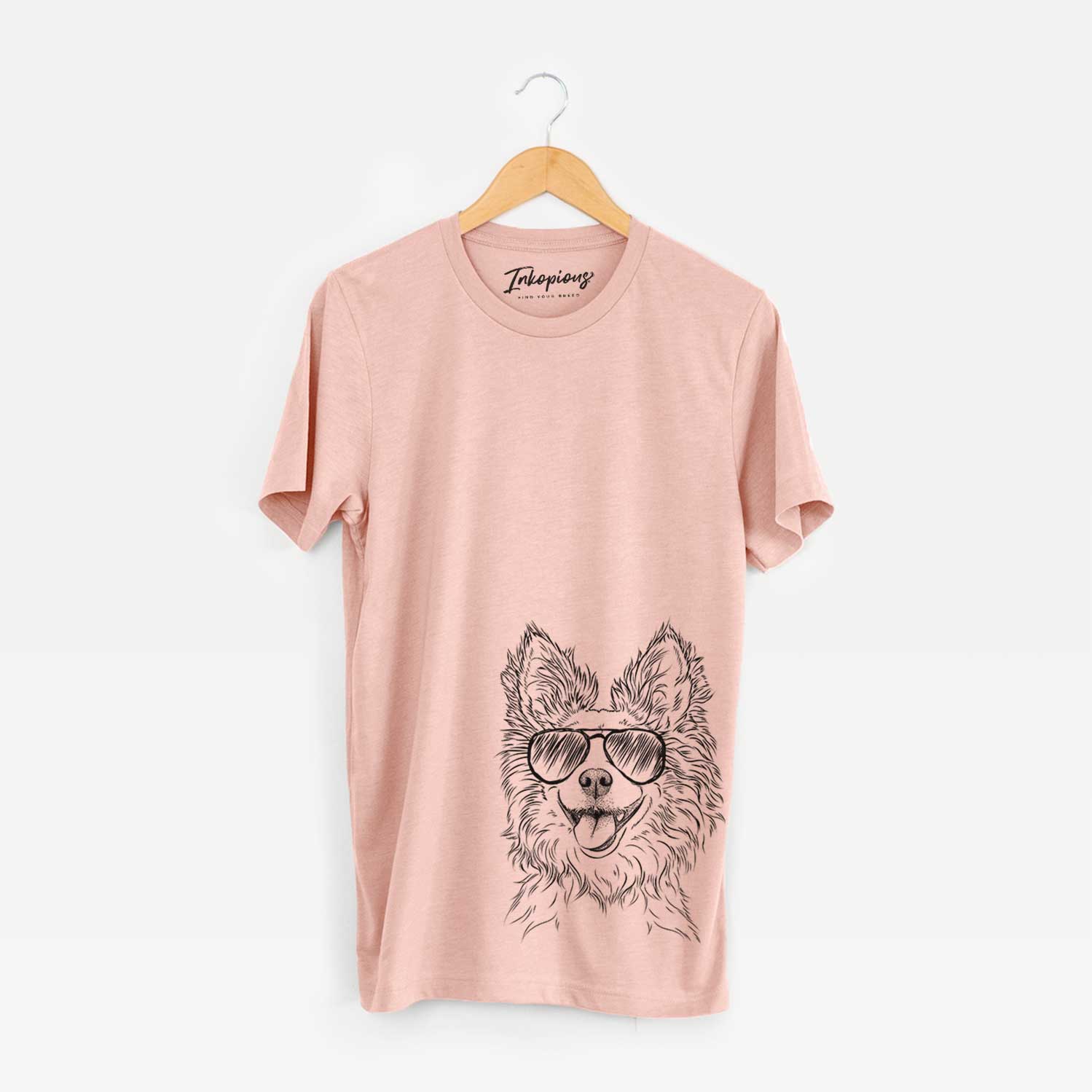 Hand-drawn sketch of Jasper the Pomchi wearing aviator sunglasses on a Peach Unisex crewneck