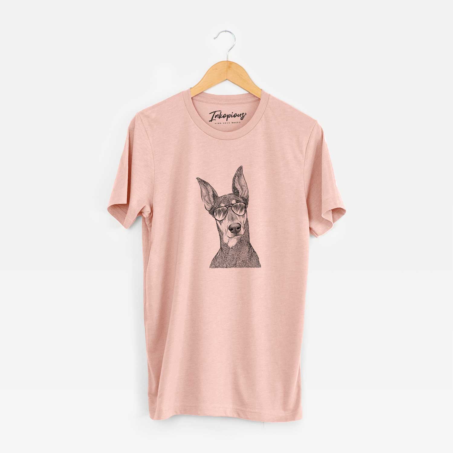 Hand-drawn sketch of Jenna the Doberman Pinscher wearing aviator sunglasses on a Peach Unisex crewneck