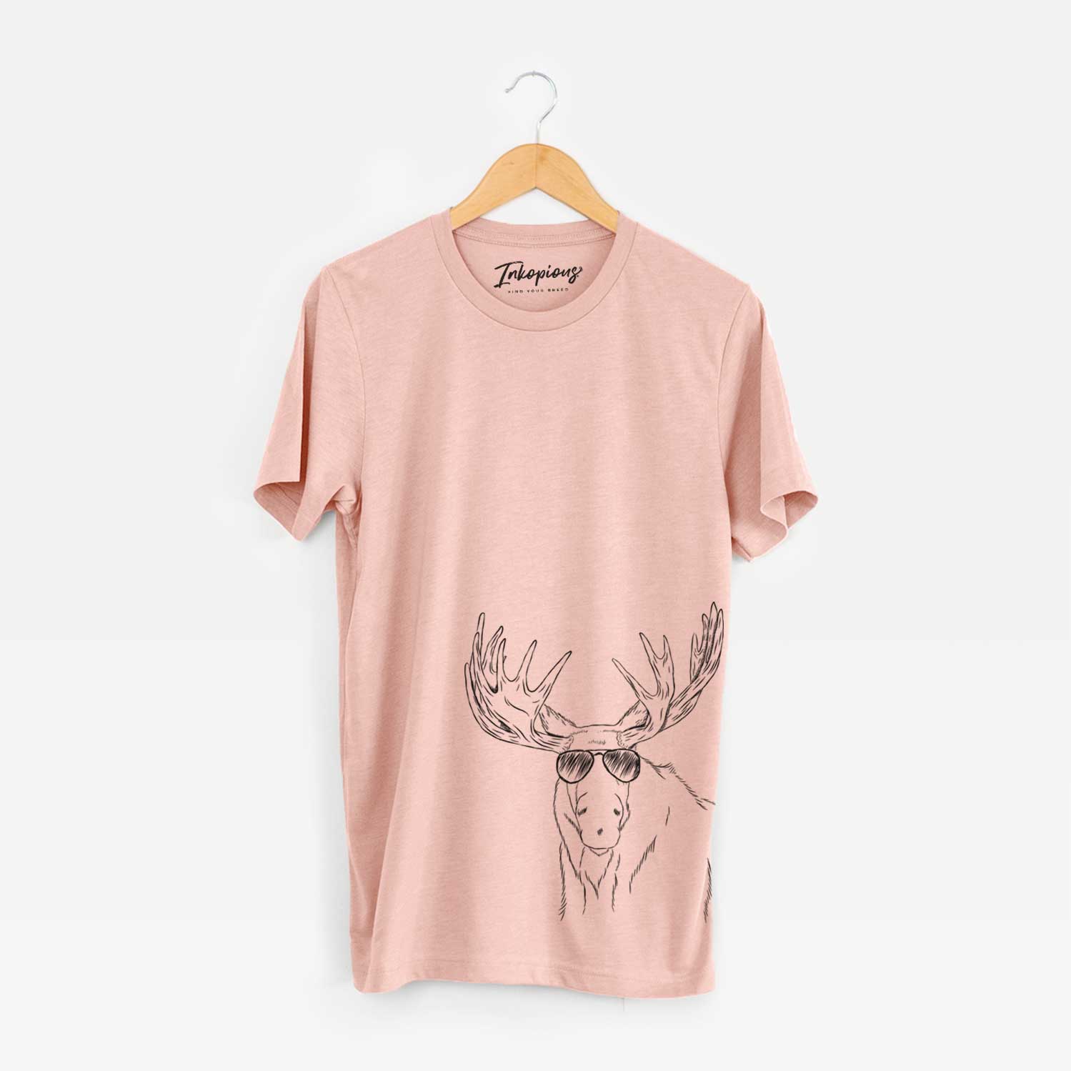 Hand-drawn sketch of Monty the Moose wearing aviator sunglasses on a Peach Unisex crewneck