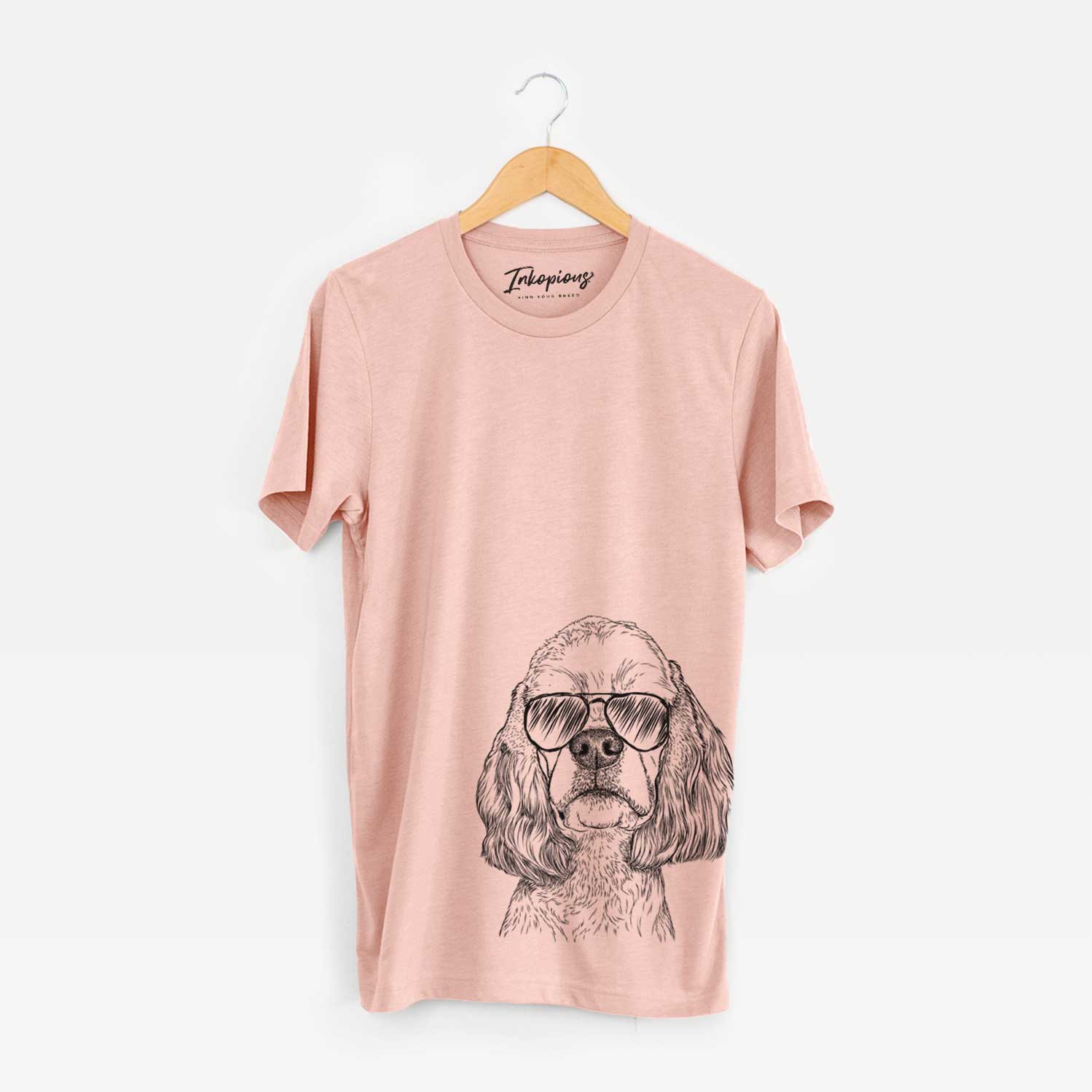 Hand-drawn sketch of Oakley the American Cocker Spaniel wearing aviator sunglasses on a Peach Bella Canvas Unisex Crewneck