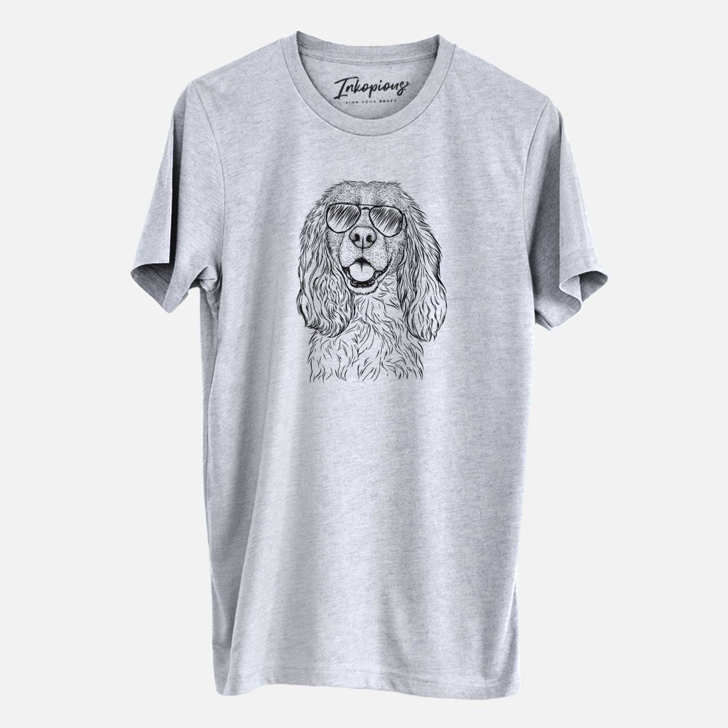 Hand-drawn sketch of Perry the Cockalier wearing aviator sunglasses on a Grey Unisex crewneck