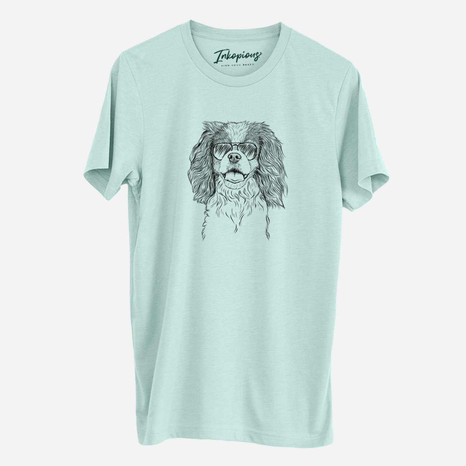 Hand-drawn sketch of Poppy the Cavalier King Charles Spaniel wearing aviator sunglasses on a Heather Sage Unisex crewneck