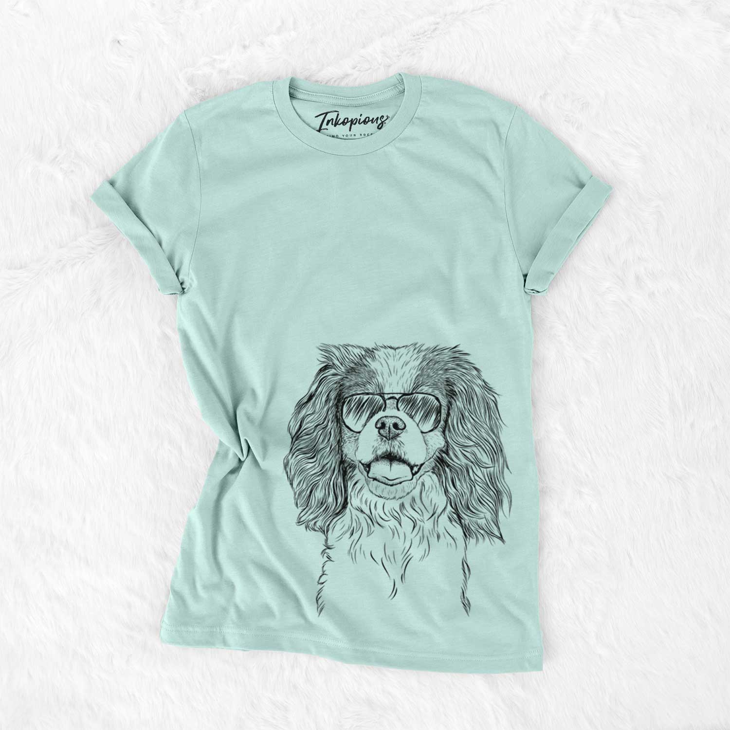 Hand-drawn sketch of Poppy the Cavalier King Charles Spaniel wearing aviator sunglasses on a Heather Sage Unisex crewneck