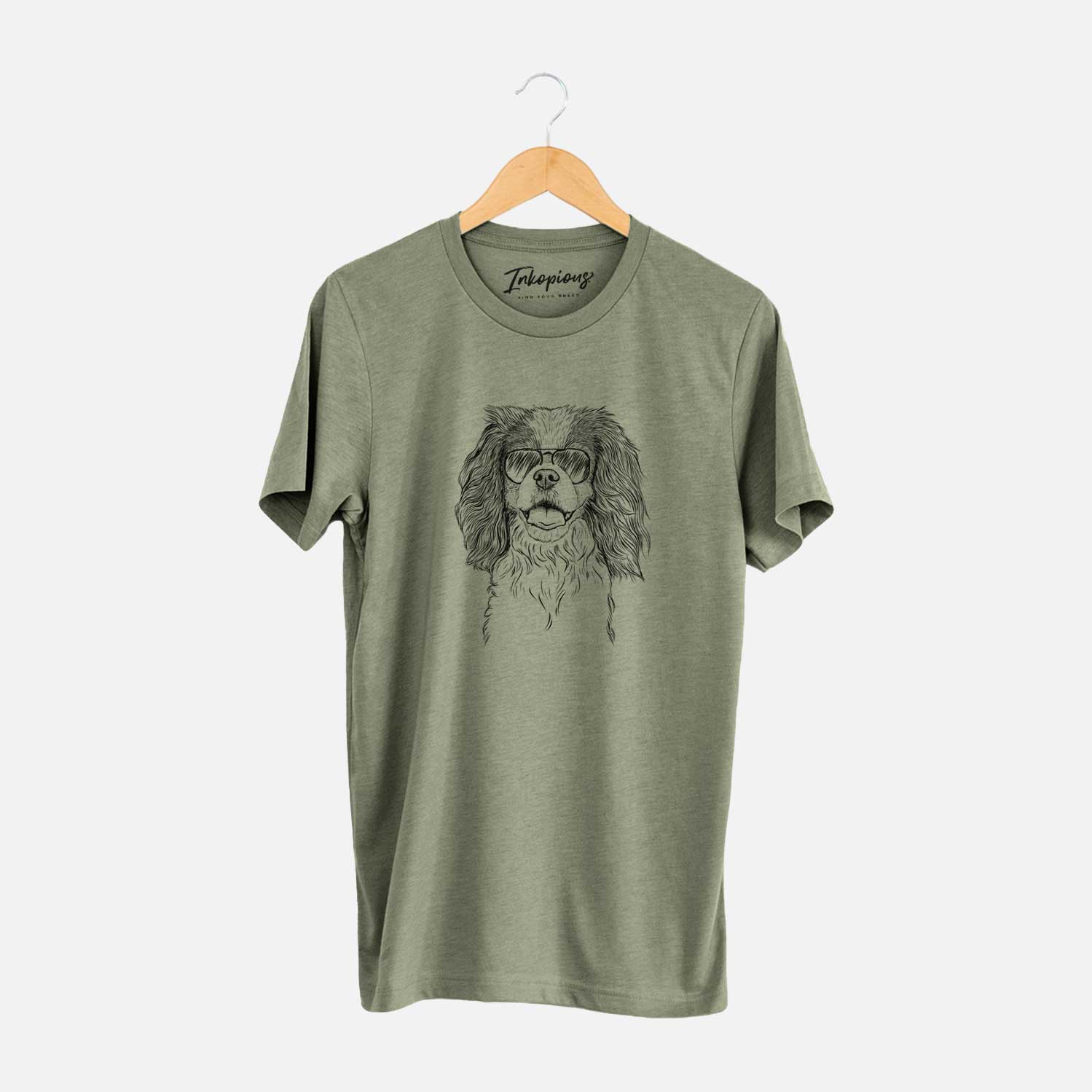 Hand-drawn sketch of Poppy the Cavalier King Charles Spaniel wearing aviator sunglasses on an Olive Unisex crewneck