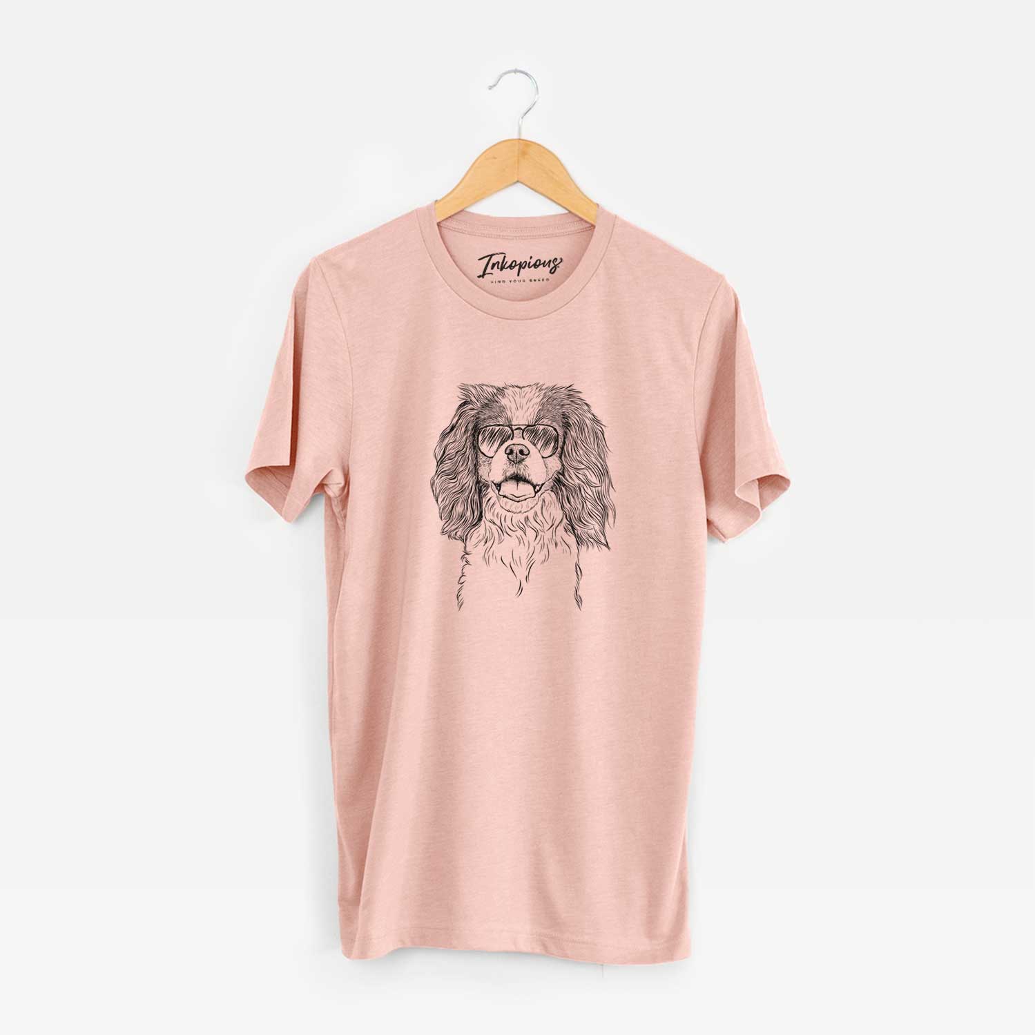 Hand-drawn sketch of Poppy the Cavalier King Charles Spaniel wearing aviator sunglasses on a Peach Unisex crewneck