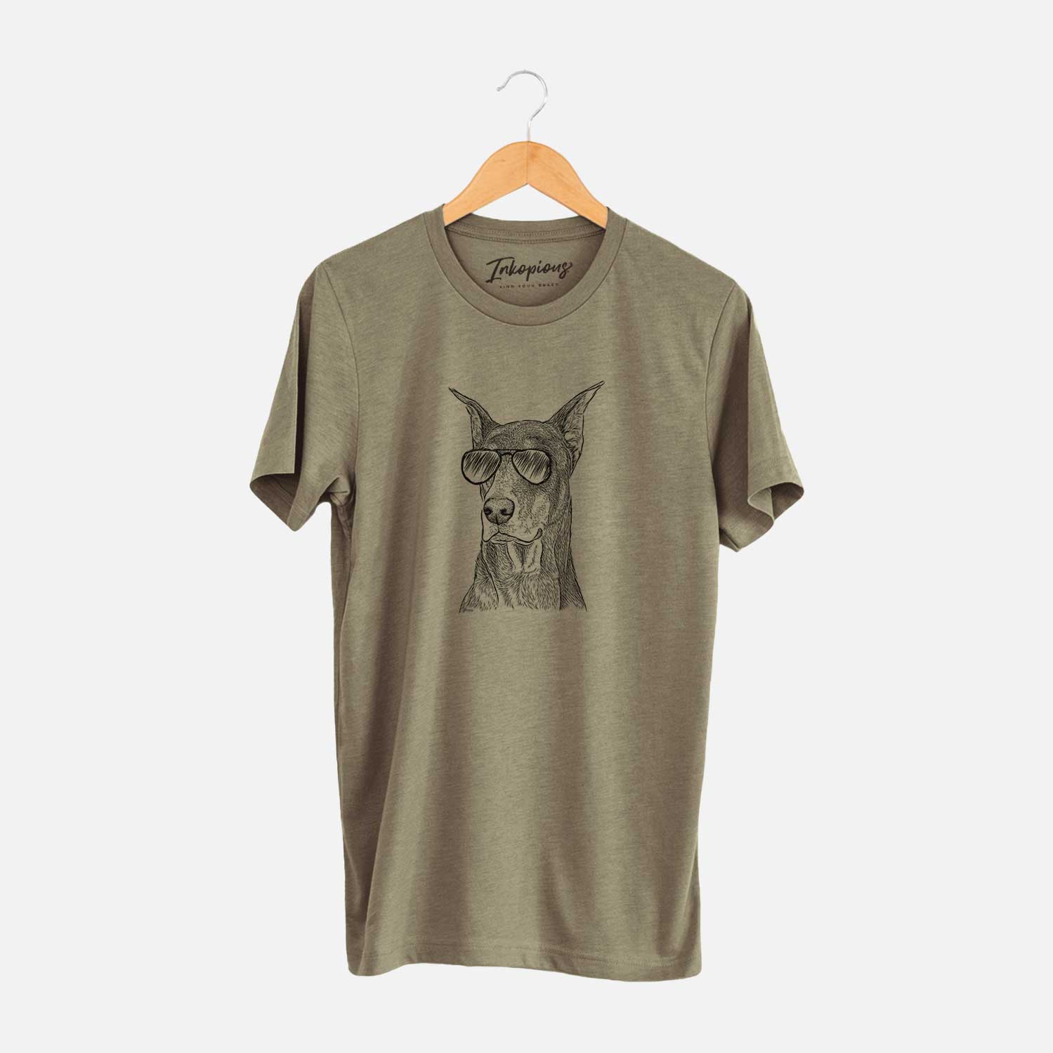 Hand-drawn sketch of RJ the Doberman Pinscher wearing aviator sunglasses on an Olive Unisex crewneck