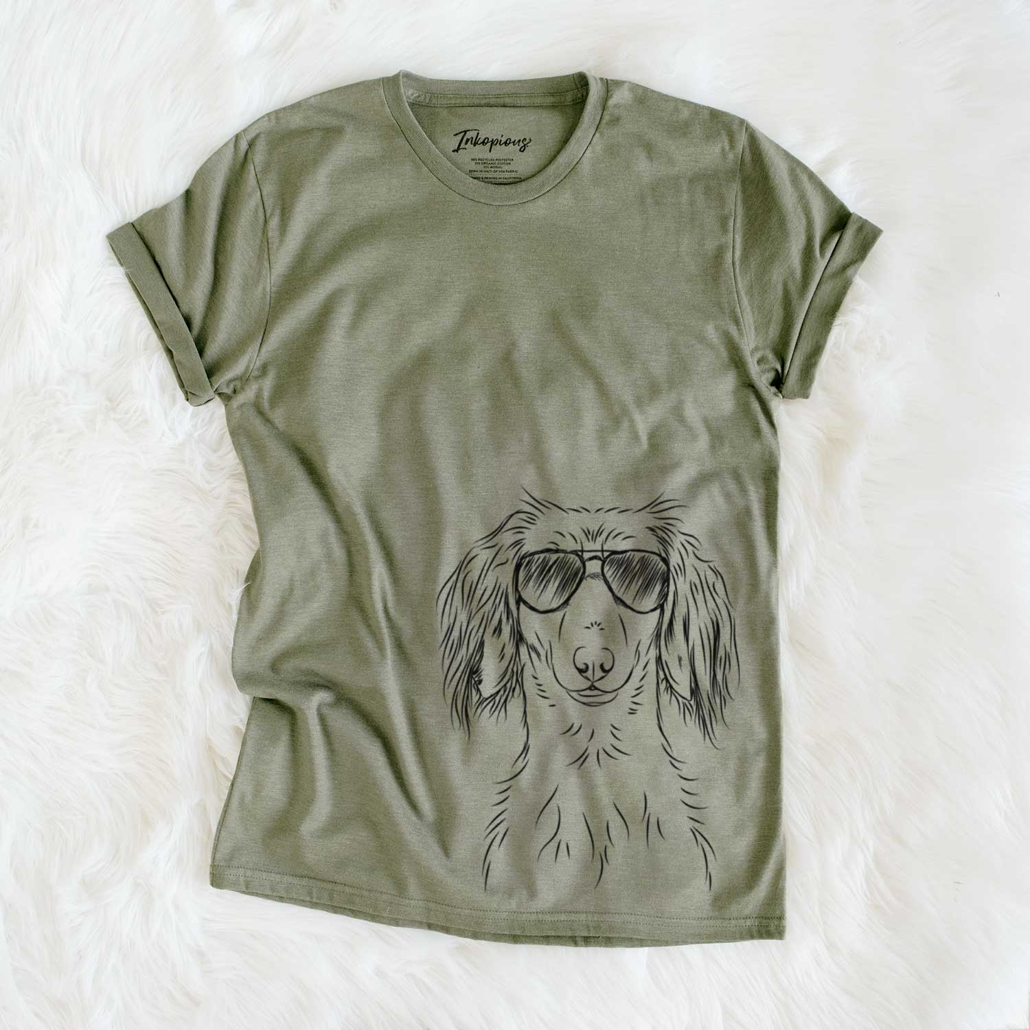Hand-drawn sketch of Roux the Long Haired Dachshund wearing aviator sunglasses on an Olive Unisex crewneck
