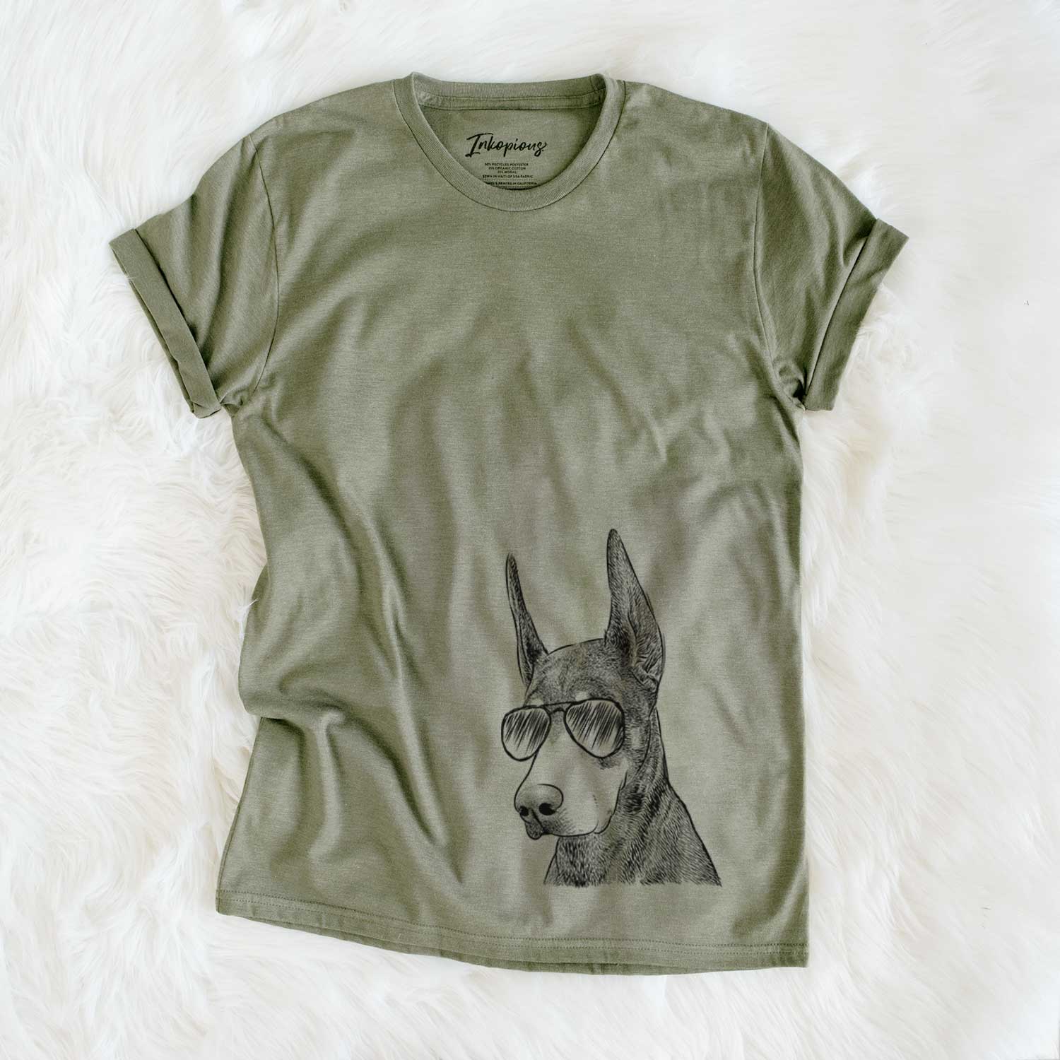 Hand-drawn sketch of Sunny the Doberman Pinscher wearing aviator sunglasses on an Olive Unisex crewneck