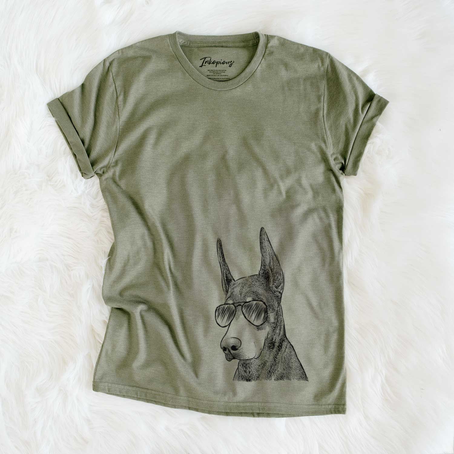 Hand-drawn sketch of Sunny the Doberman Pinscher wearing aviator sunglasses on an Olive Unisex crewneck