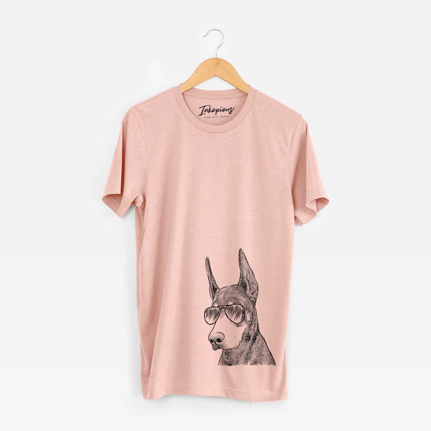 Hand-drawn sketch of Sunny the Doberman Pinscher wearing aviator sunglasses on a Peach Bella Canvas Unisex Crewneck