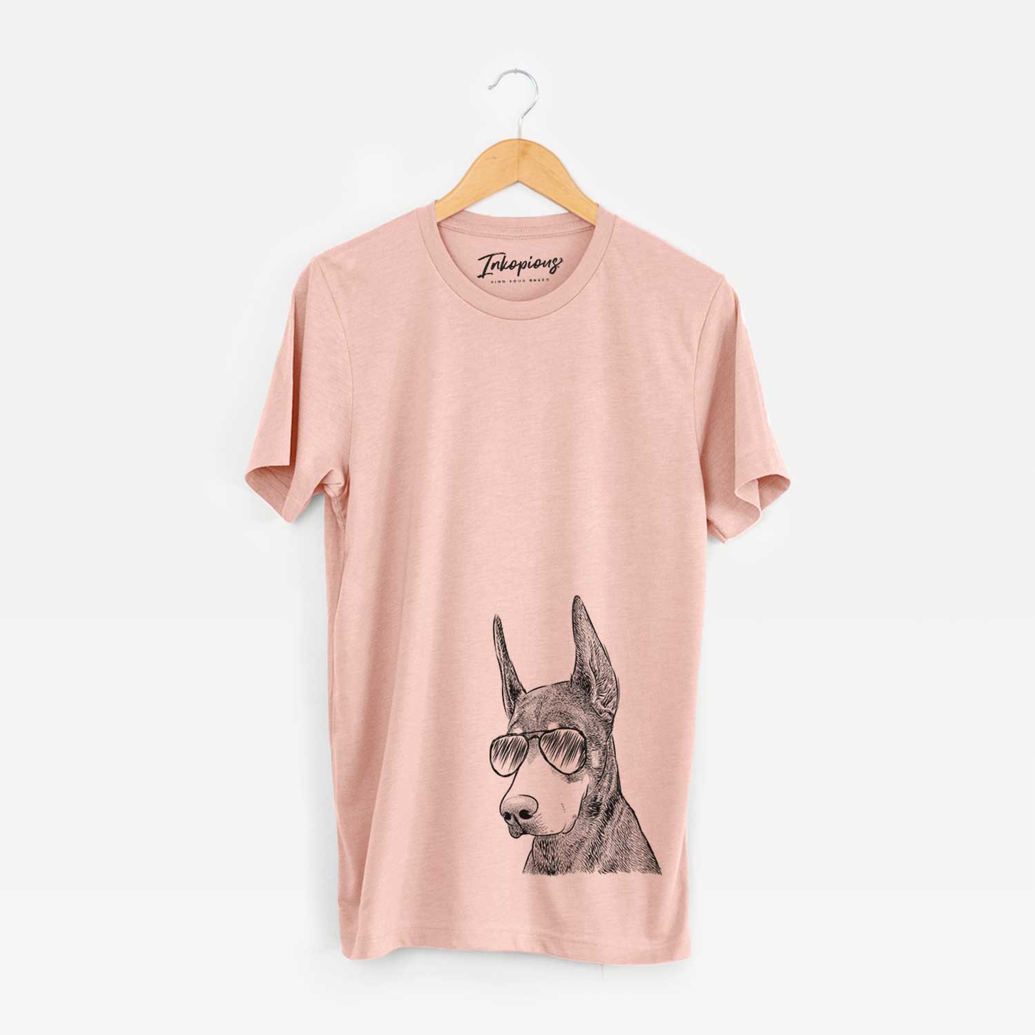 Hand-drawn sketch of Sunny the Doberman Pinscher wearing aviator sunglasses on a Peach Unisex crewneck