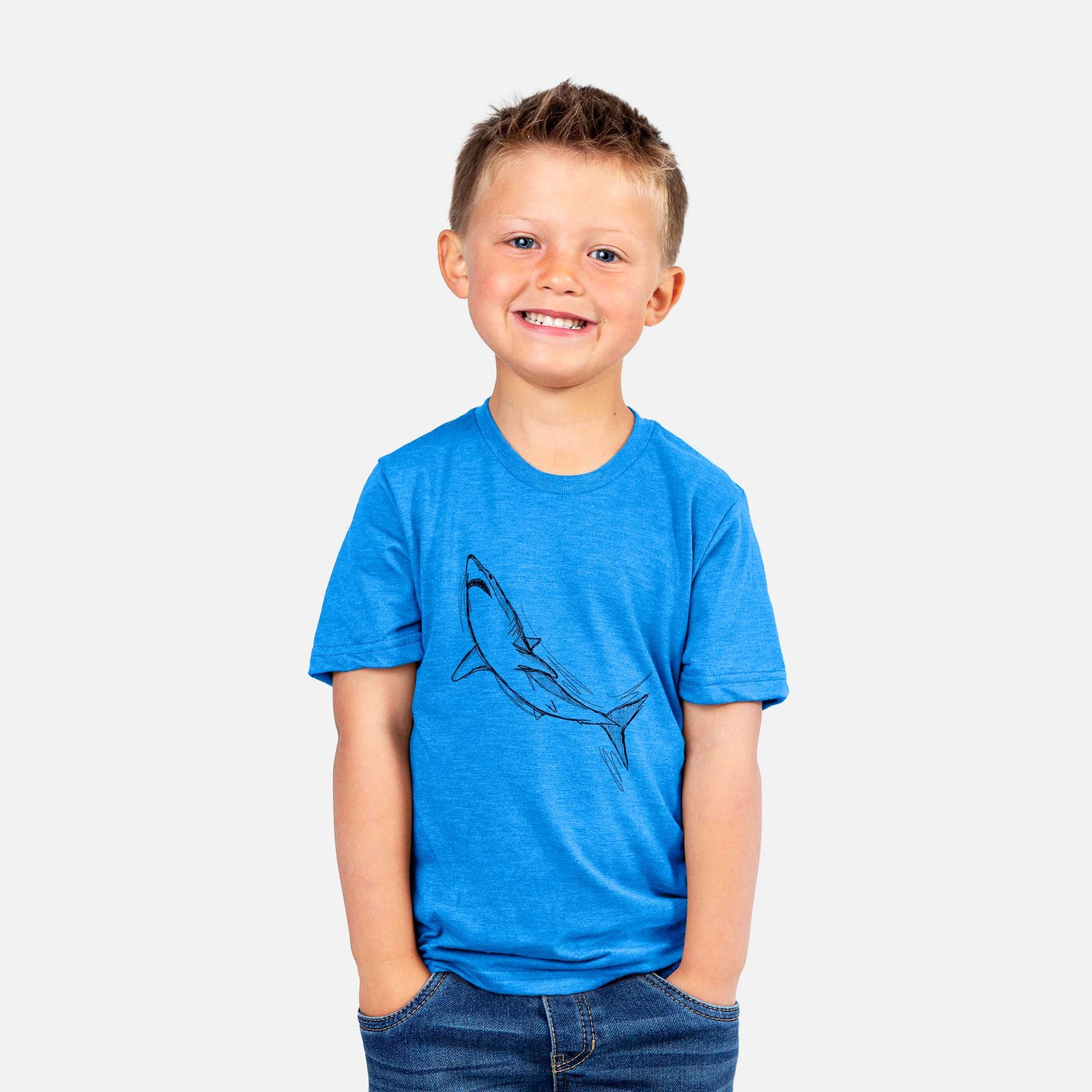 Hand-drawn sketch of Anchor the Mako Shark on a kids' shirt, worn by a boy