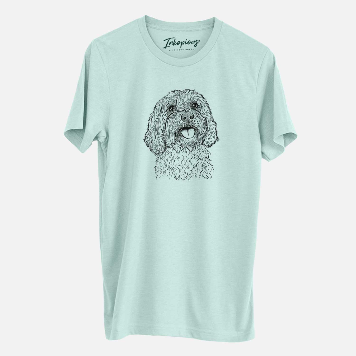 Hand-drawn sketch of Cali the Cavapoo on a Heather Sage Unisex crewneck