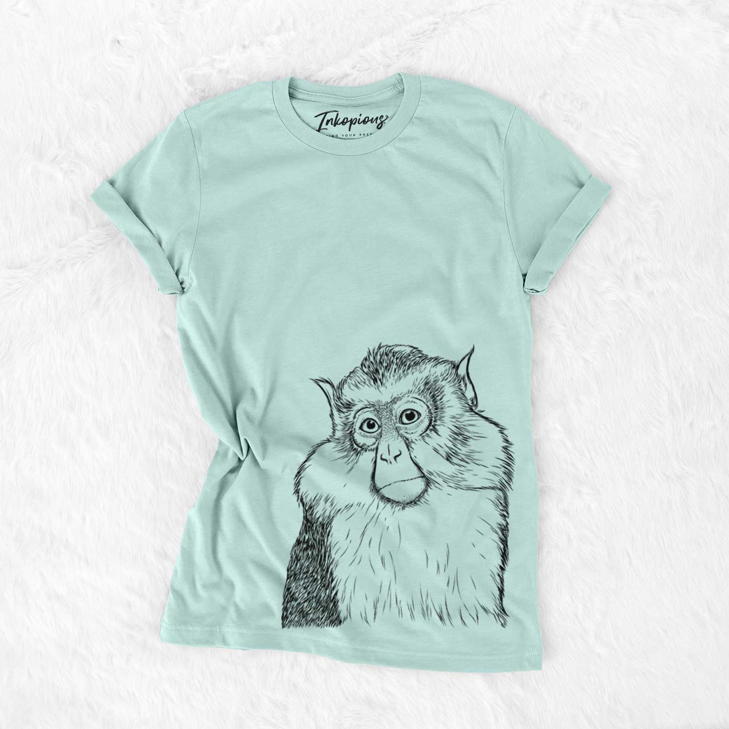 Hand-drawn sketch of Matata the Mona Monkey on a Heather Sage Unisex crewneck