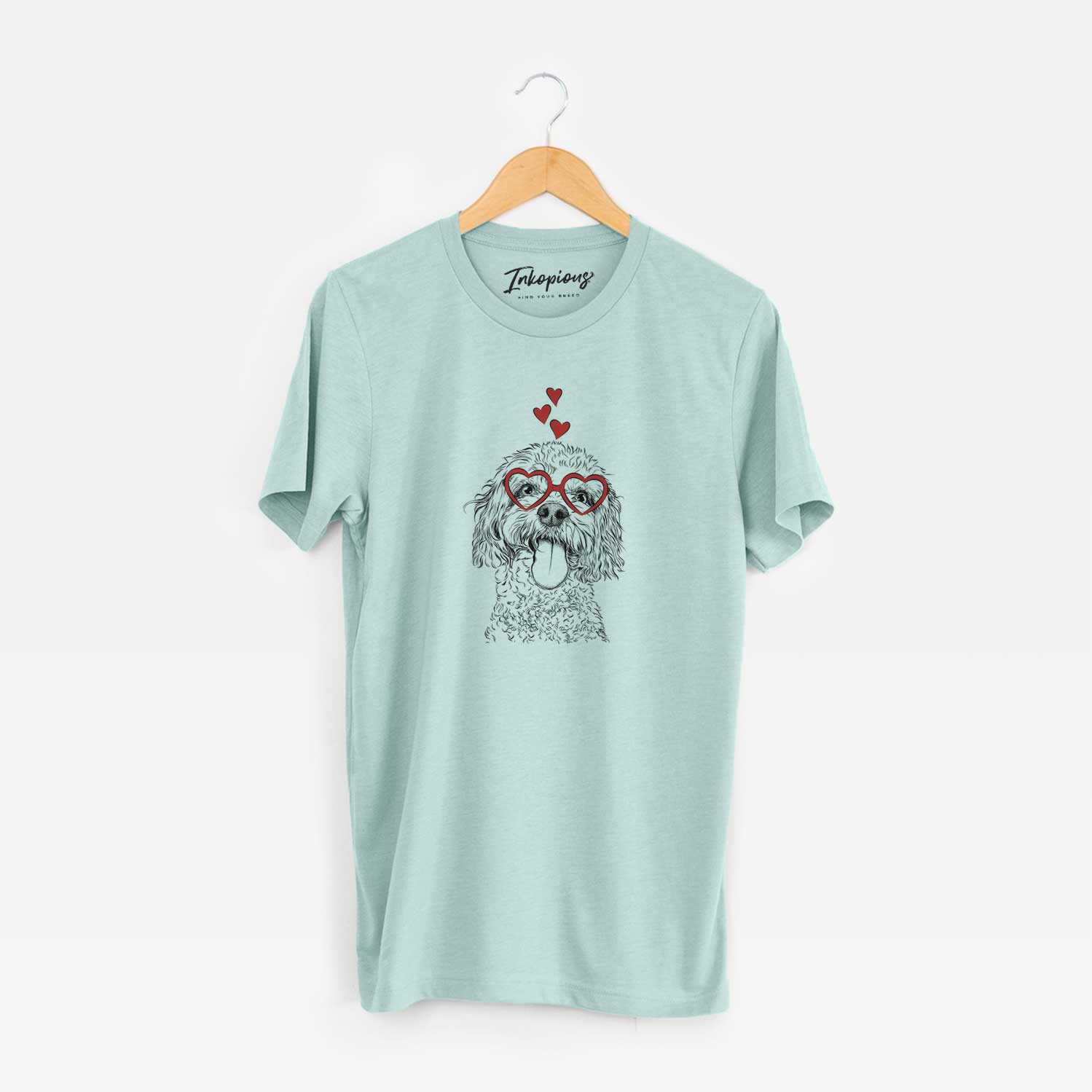 Hand-drawn sketch of Barney the Cavachon wearing heart-shaped glasses on a Heather Sage Unisex crewneck