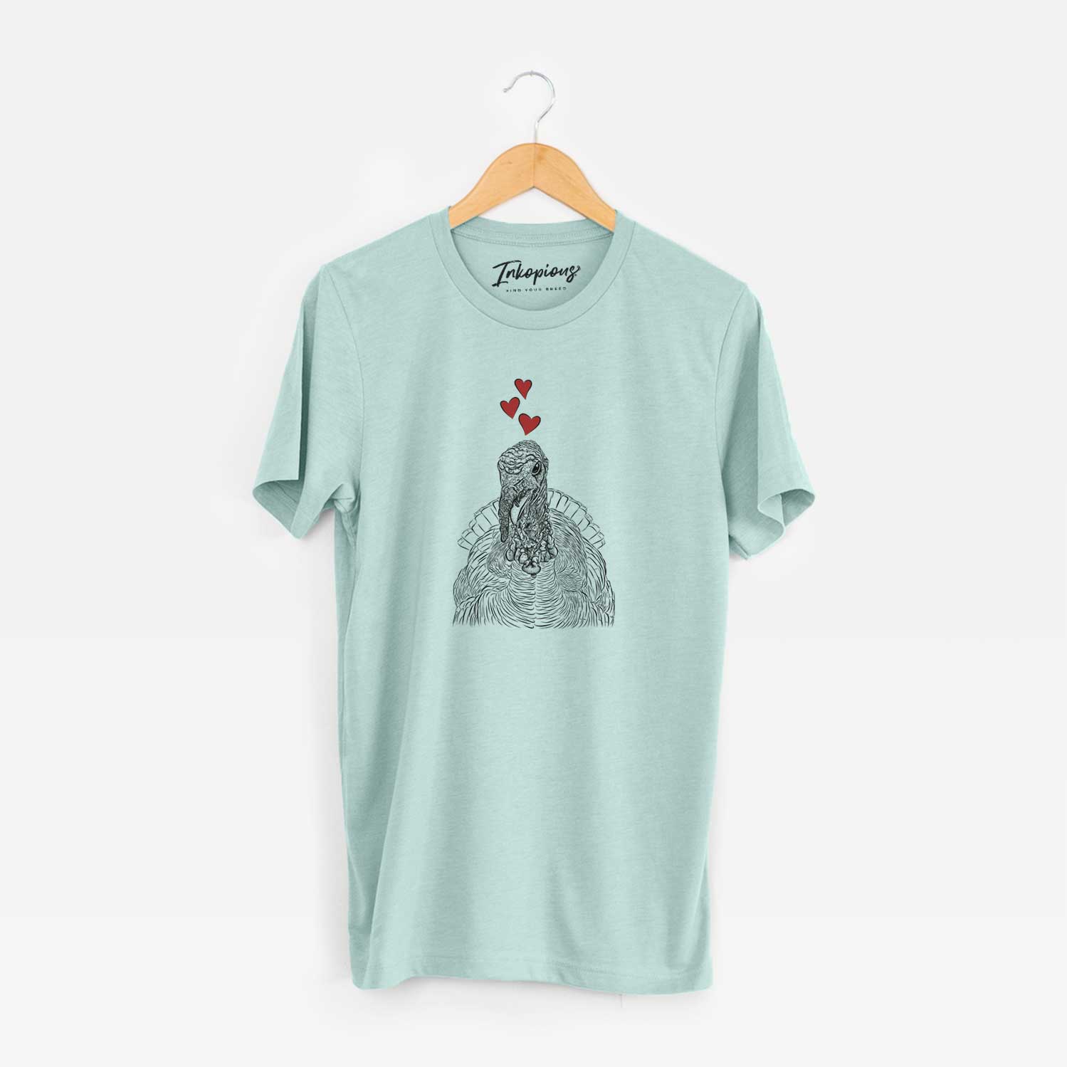 Hand-drawn sketch of Brady the Turkey wearing heart-shaped glasses on a Heather Sage Unisex crewneck