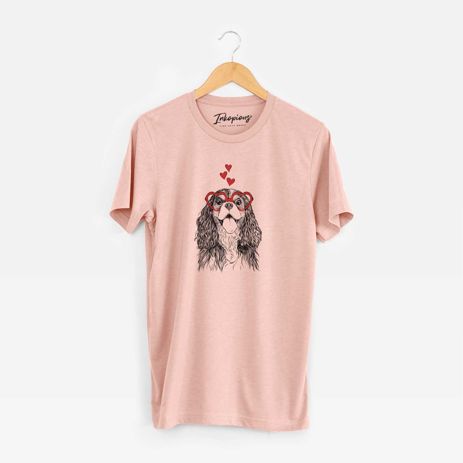 Hand-drawn sketch of Brandy the Cavalier King Charles Spaniel wearing heart-shaped glasses on a Peach Unisex crewneck
