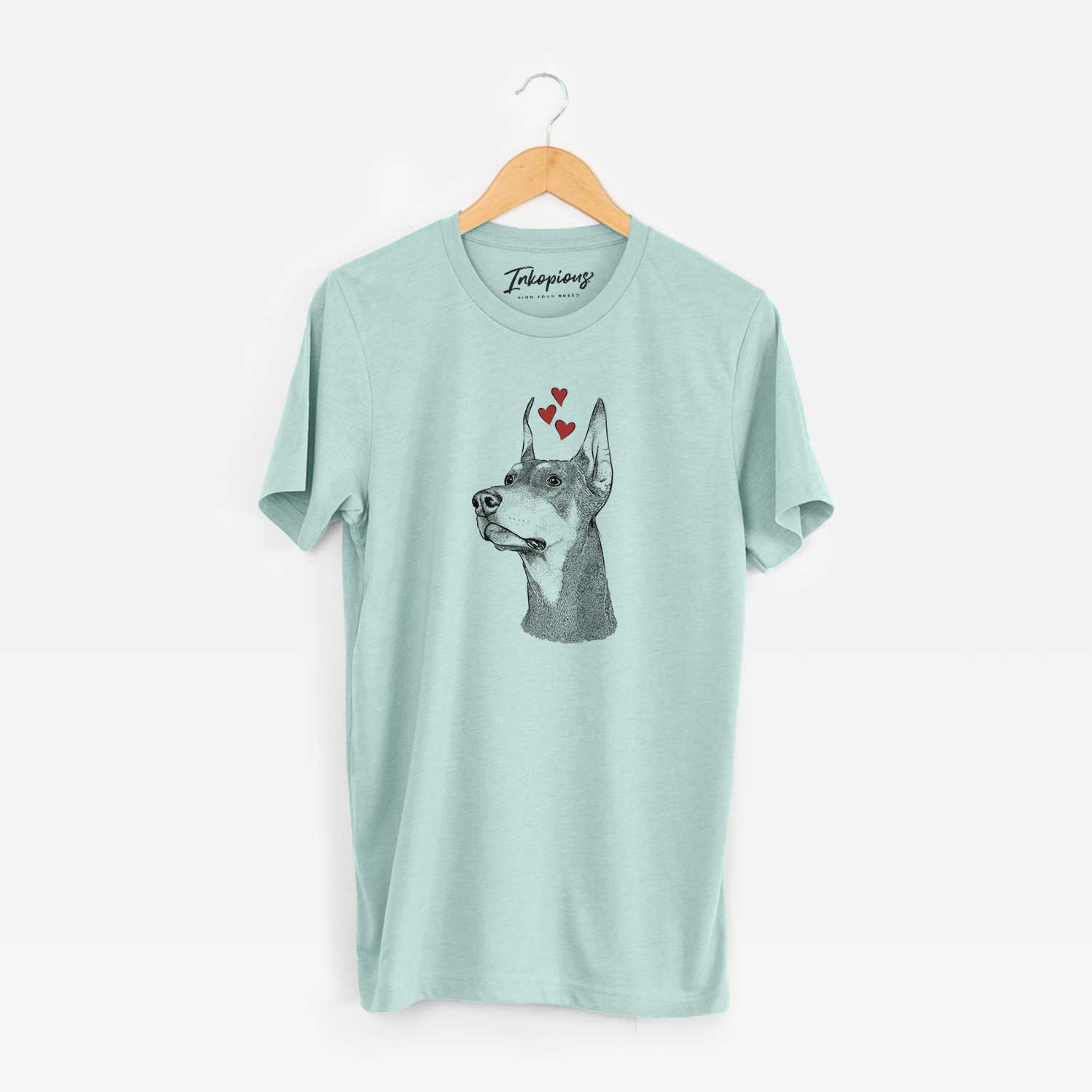 Hand-drawn sketch of Cenza the Doberman Pinscher wearing heart-shaped glasses on a Heather Sage Unisex crewneck