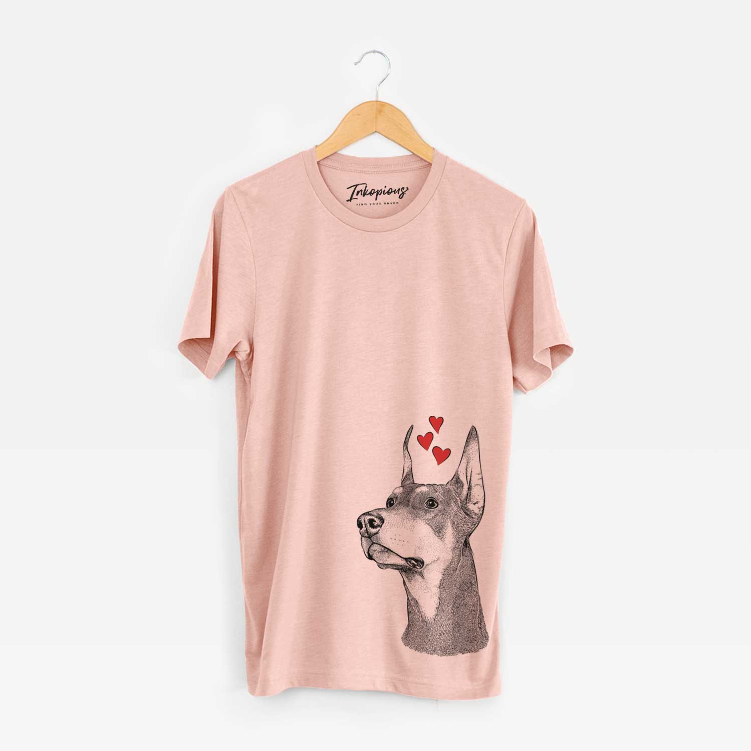 Hand-drawn sketch of Cenza the Doberman Pinscher wearing heart-shaped glasses on a Peach Unisex crewneck