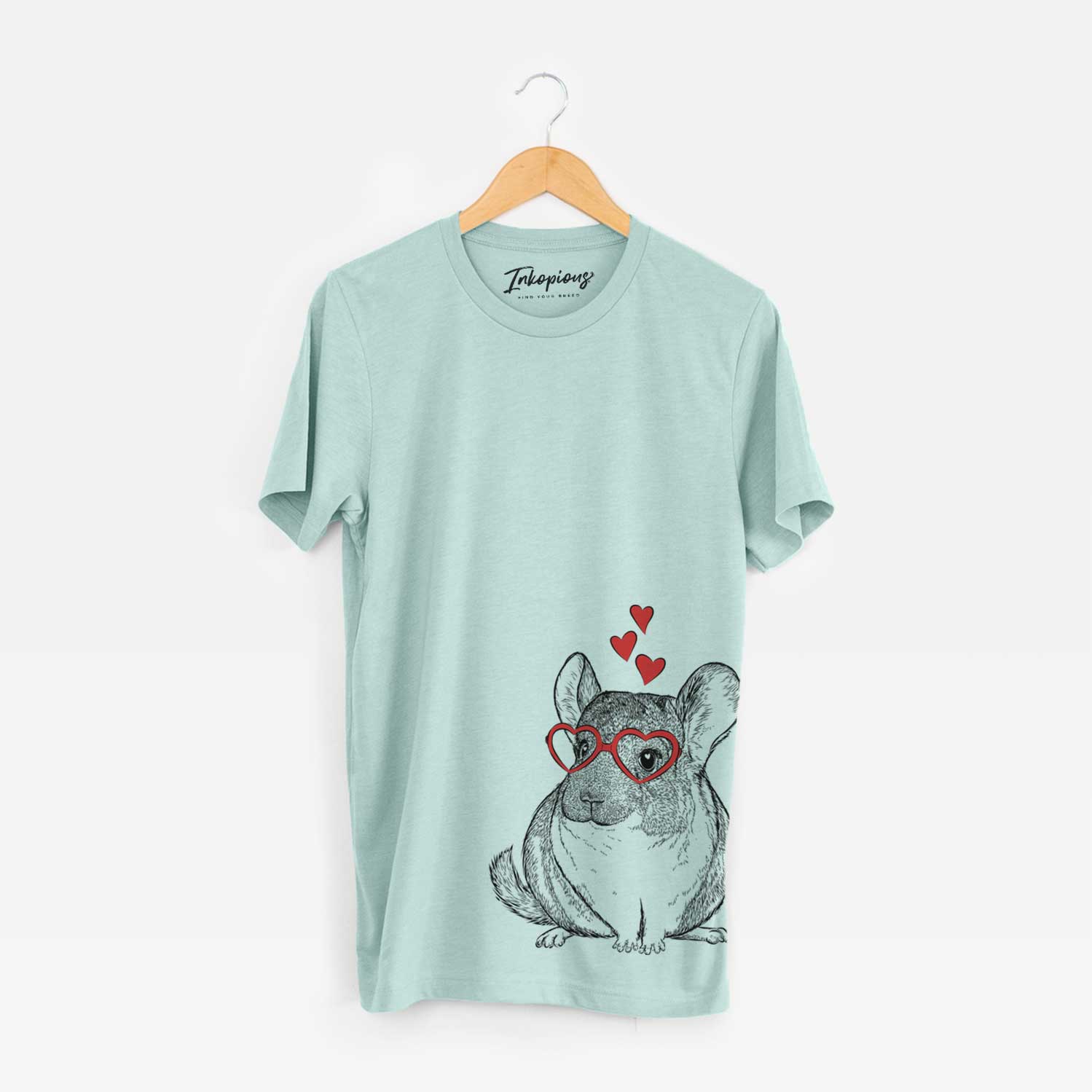 Hand-drawn sketch of Cheddar the Chinchilla wearing heart-shaped glasses on a Heather Sage Unisex crewneck