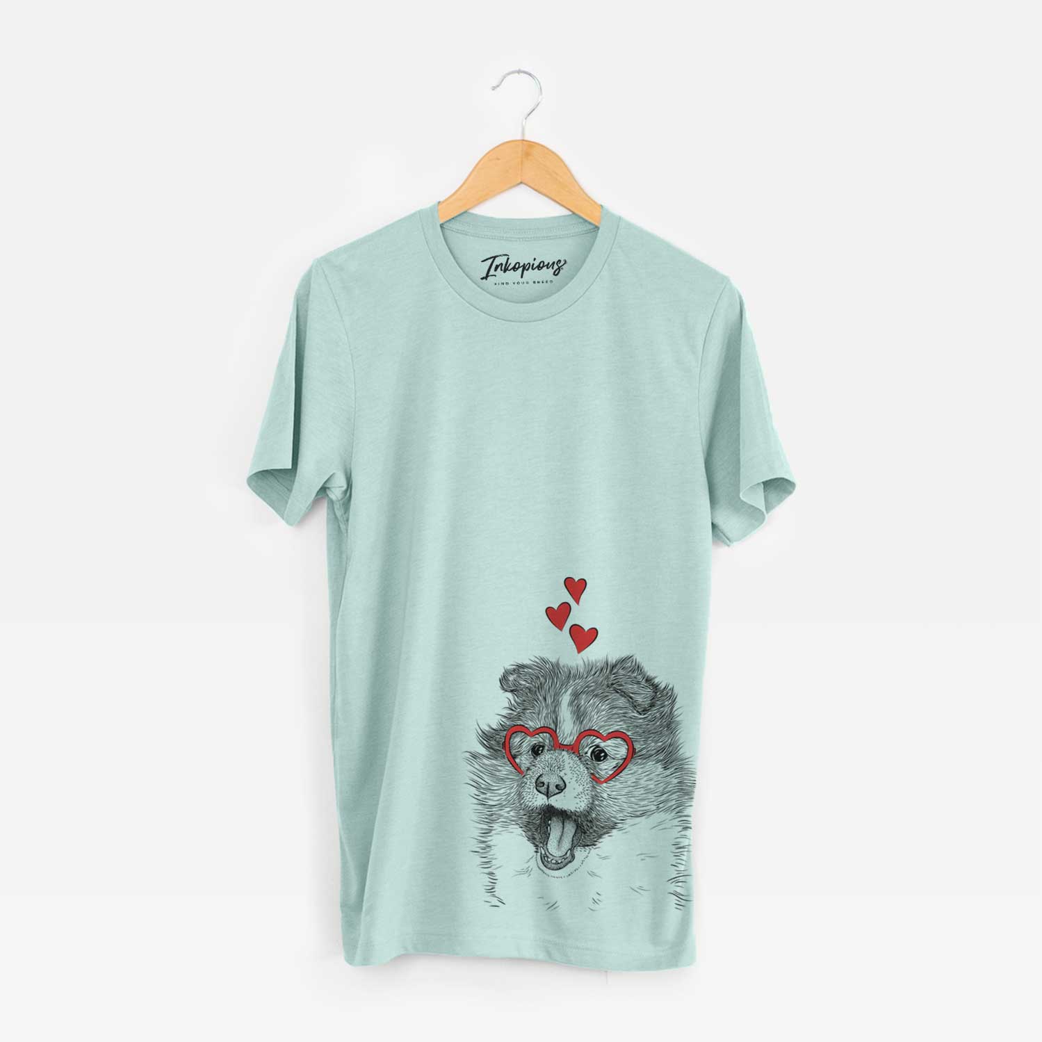 Hand-drawn sketch of Dylan the Shetland Sheepdog wearing heart-shaped glasses on a Heather Sage Unisex crewneck