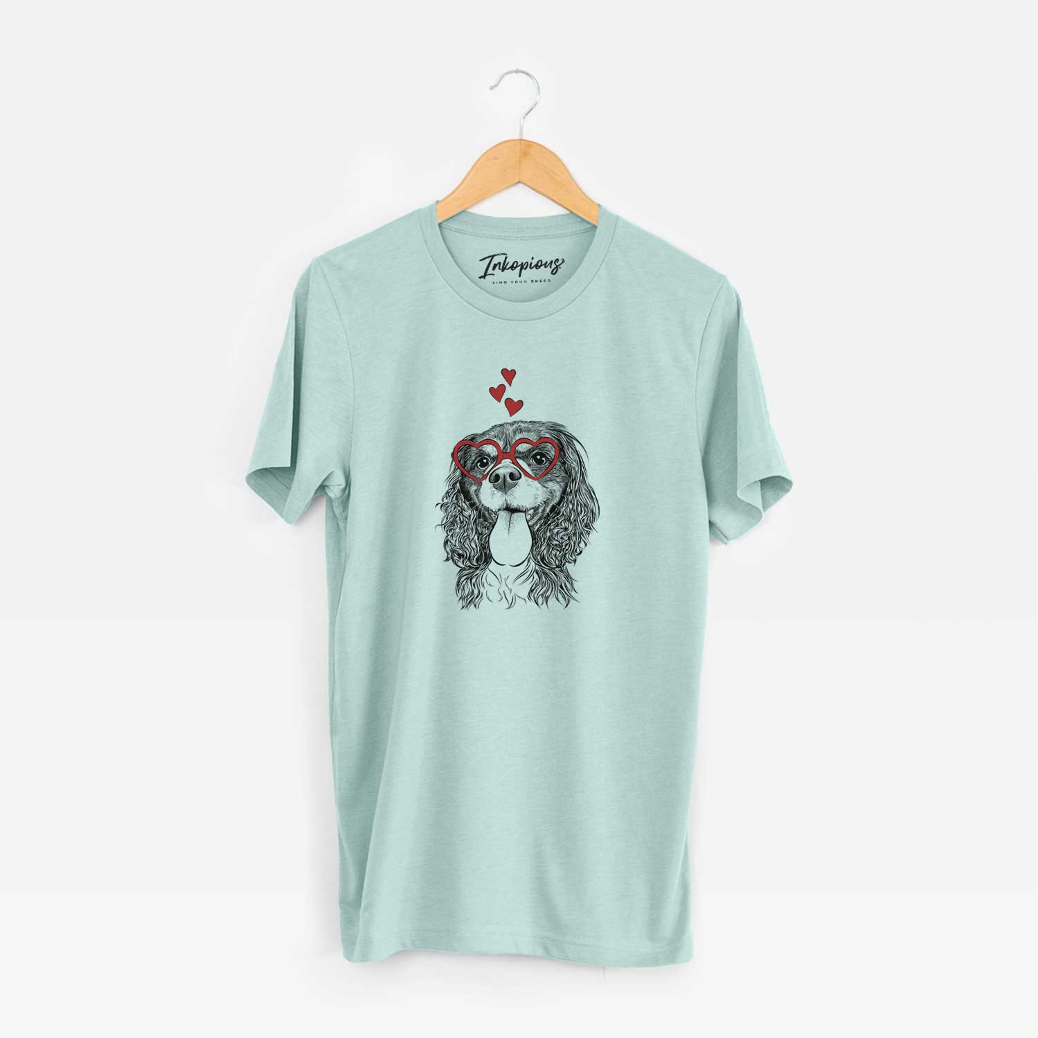 Hand-drawn sketch of Elizabeth the Cavalier King Charles Spaniel wearing heart-shaped glasses on a Heather Sage Unisex crewneck