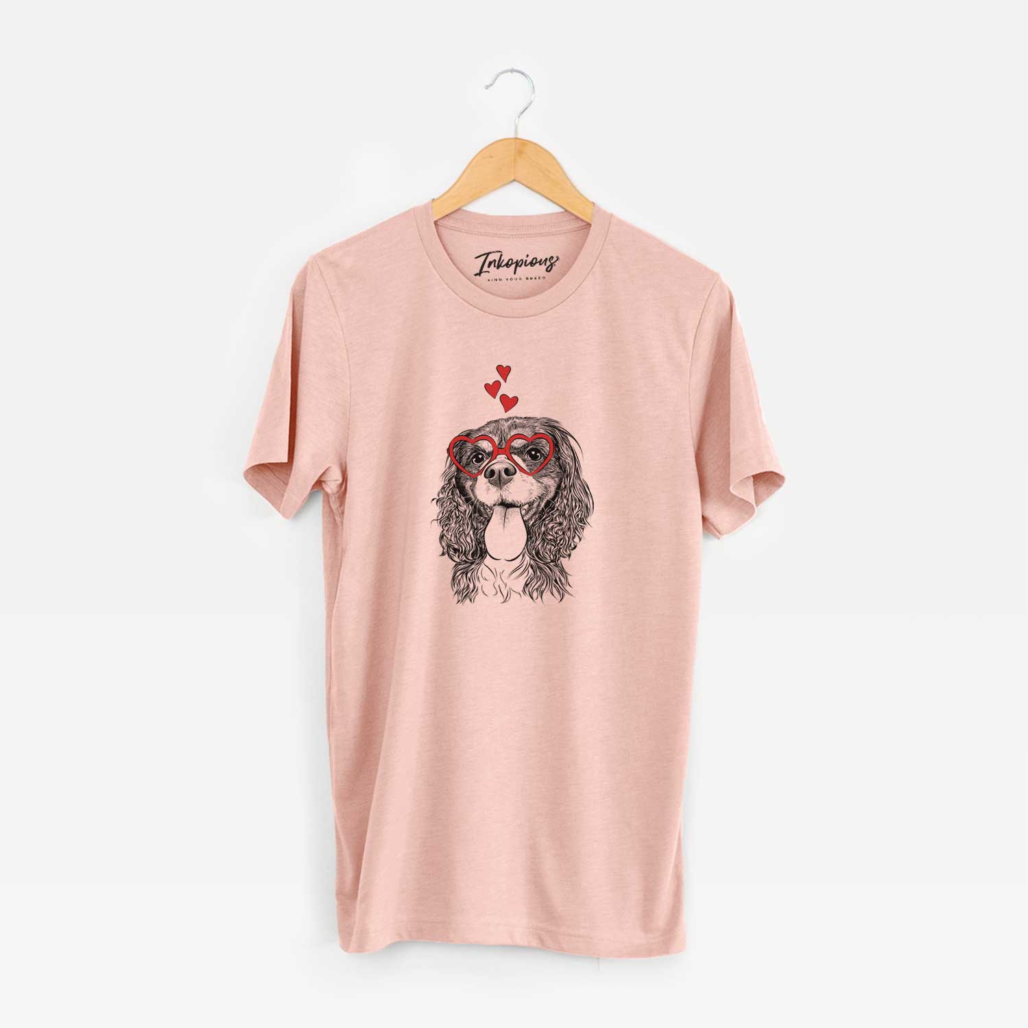 Hand-drawn sketch of Elizabeth the Cavalier King Charles Spaniel wearing heart-shaped glasses on a Peach Unisex crewneck