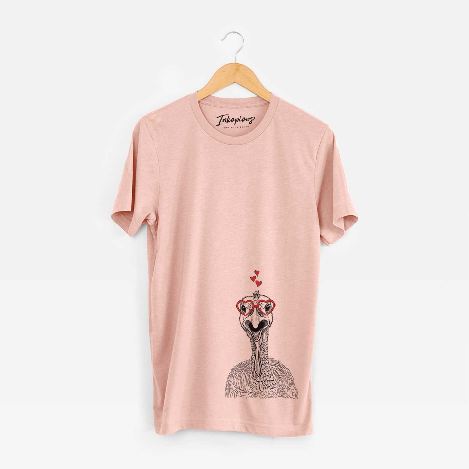 Hand-drawn sketch of Gobble the Turkey wearing heart-shaped glasses on a Peach Unisex crewneck