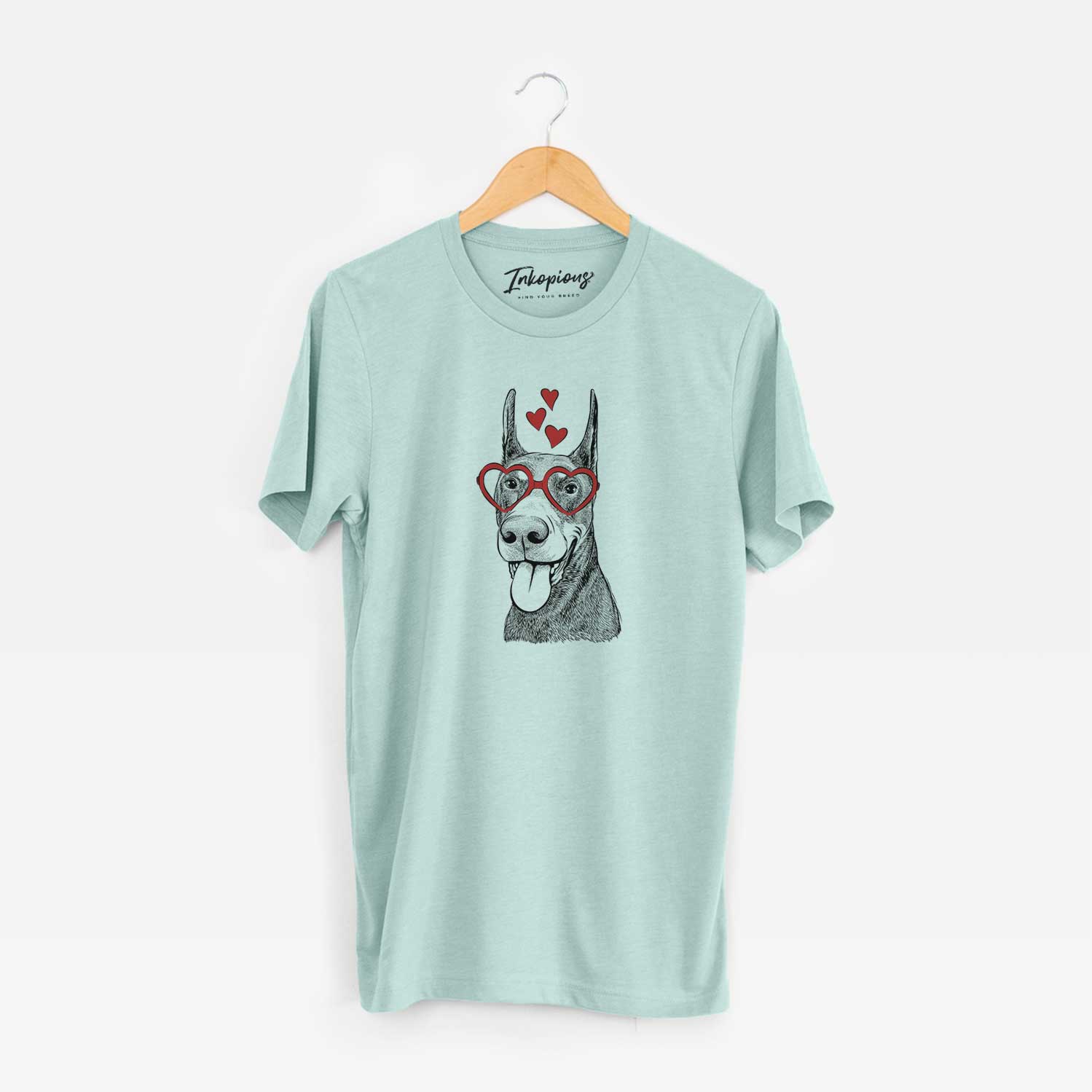 Hand-drawn sketch of Happy Sunny the Doberman Pinscher wearing heart-shaped glasses on a Heather Sage Unisex crewneck