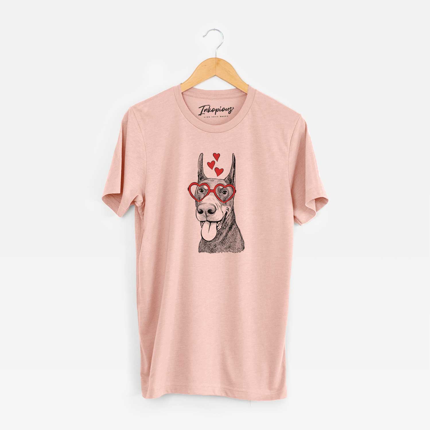 Hand-drawn sketch of Happy Sunny the Doberman Pinscher wearing heart-shaped glasses on a Peach Unisex crewneck