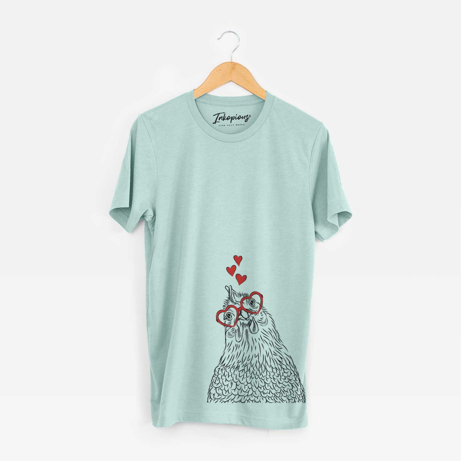 Hand-drawn sketch of Henrietta the Chicken wearing heart-shaped glasses on a Heather Sage Unisex crewneck