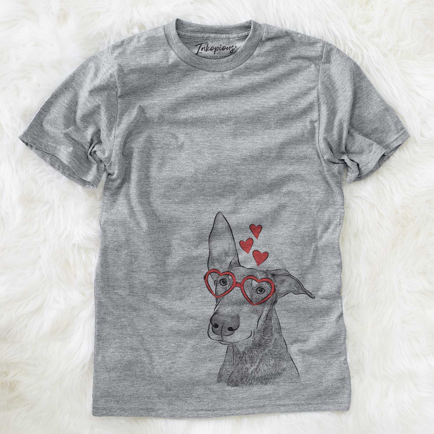 Hand-drawn sketch of Kain the Doberman Pinscher wearing heart-shaped glasses on a Grey Unisex crewneck