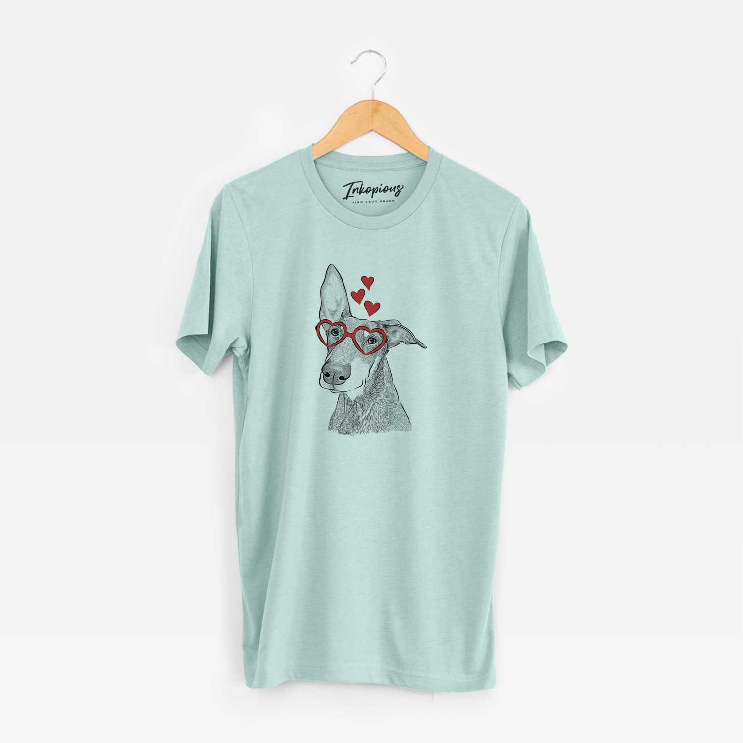 Hand-drawn sketch of Kain the Doberman Pinscher wearing heart-shaped glasses on a Heather Sage Unisex crewneck