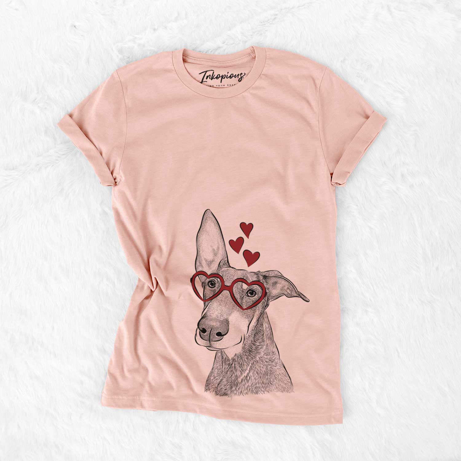 Hand-drawn sketch of Kain the Doberman Pinscher wearing heart-shaped glasses on a Peach Bella Canvas Unisex Crewneck