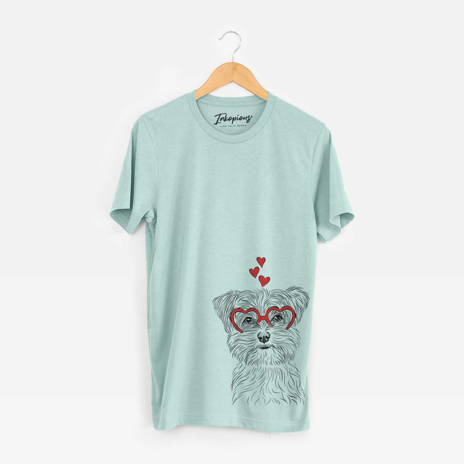 Hand-drawn sketch of Kiwi the Morkie wearing heart-shaped glasses on a Heather Sage Unisex crewneck