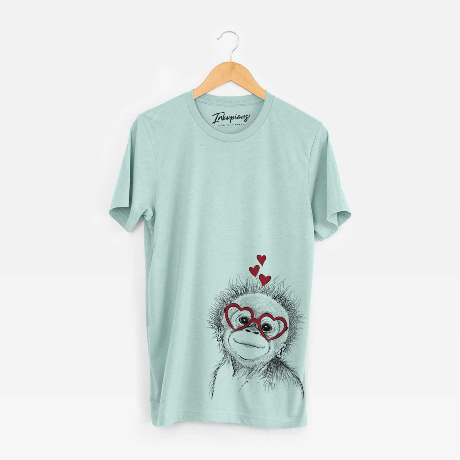 Hand-drawn sketch of Louie the Baby Orangutan wearing heart-shaped glasses on a Heather Sage Bella Canvas Unisex Crewneck