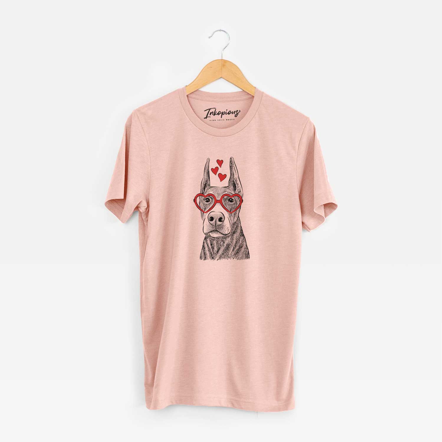 Hand-drawn sketch of Luna the Doberman Pinscher wearing heart-shaped glasses on a Peach Unisex crewneck