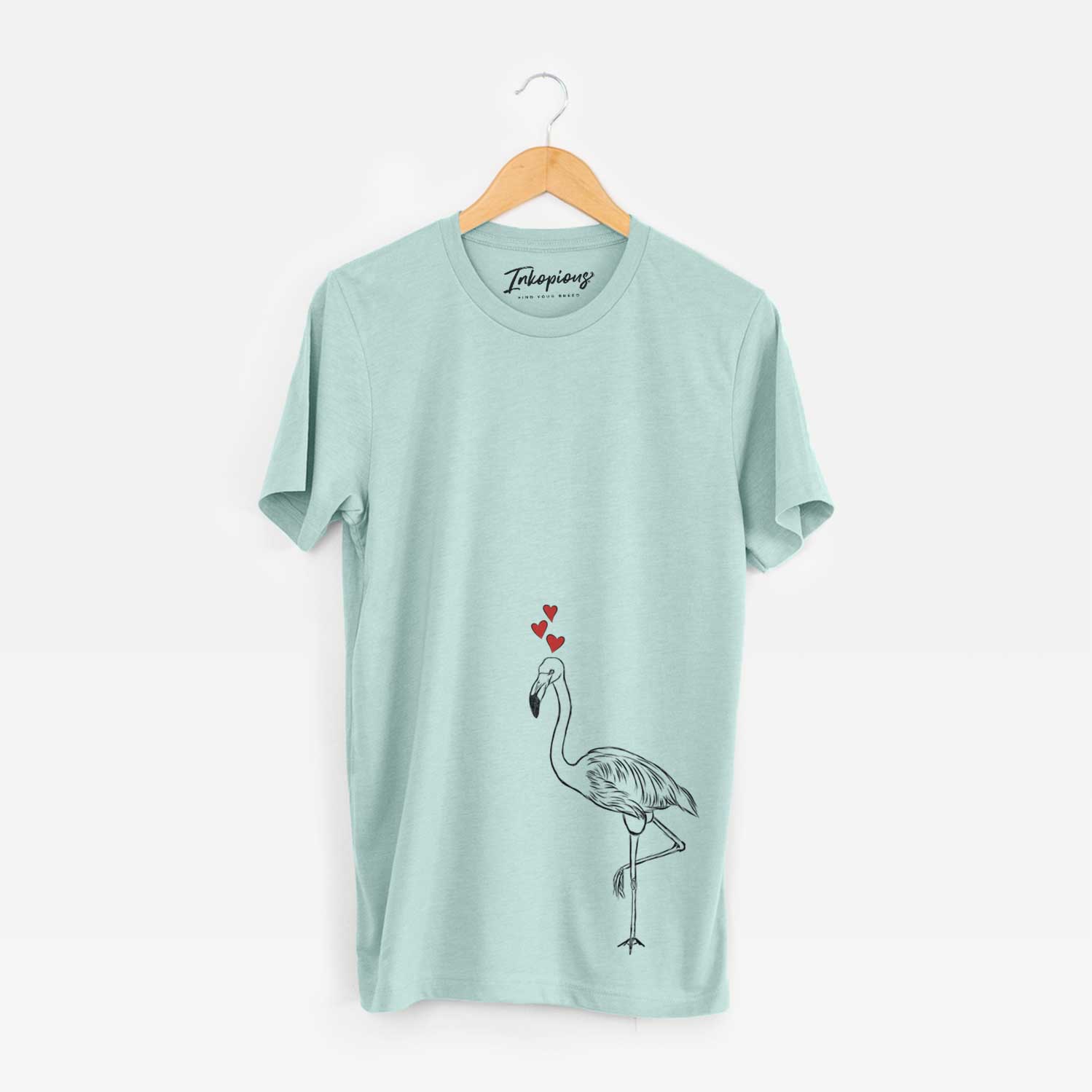 Hand-drawn sketch of Mango the Flamingo wearing heart-shaped glasses on a Heather Sage Unisex crewneck