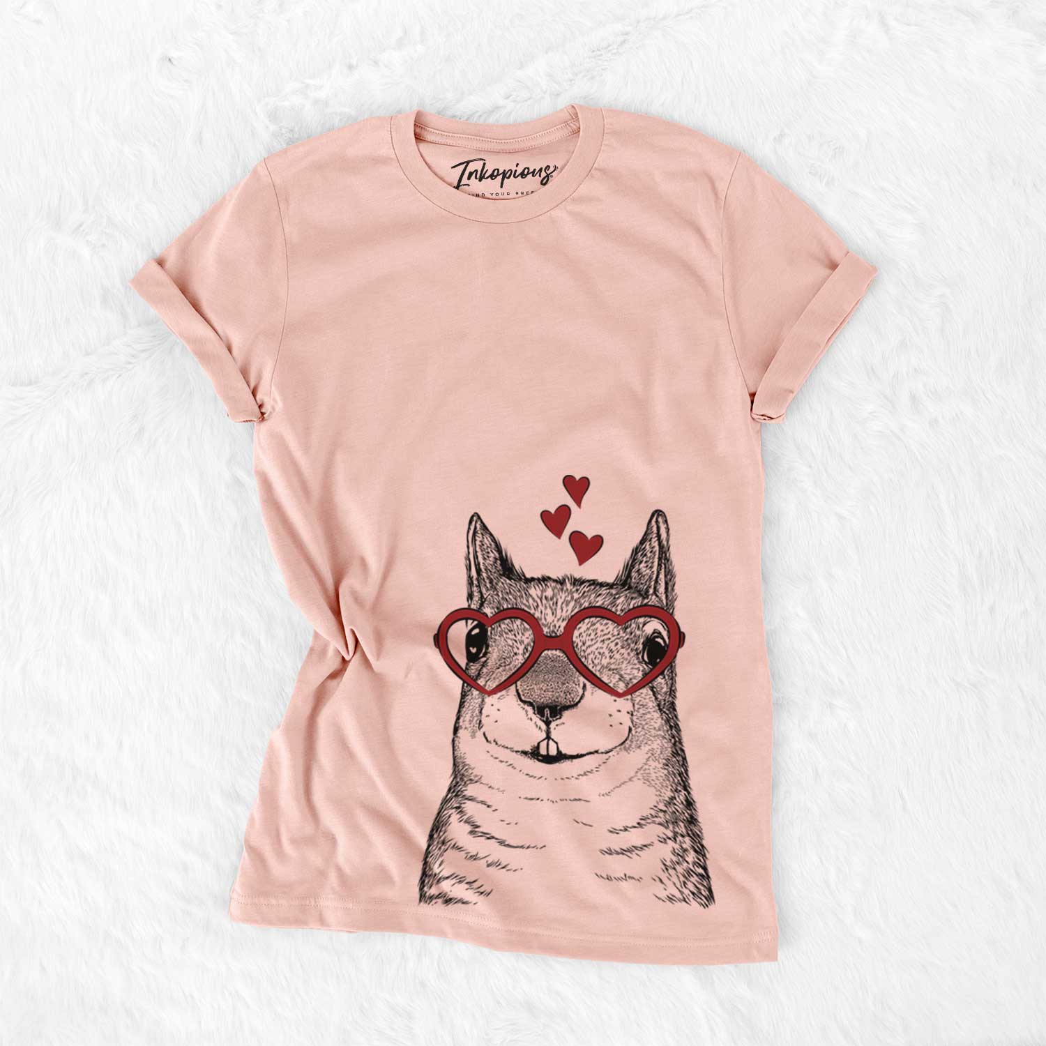 Hand-drawn sketch of Nibbles the Squirrel wearing heart-shaped glasses on a Peach Bella Canvas Unisex Crewneck