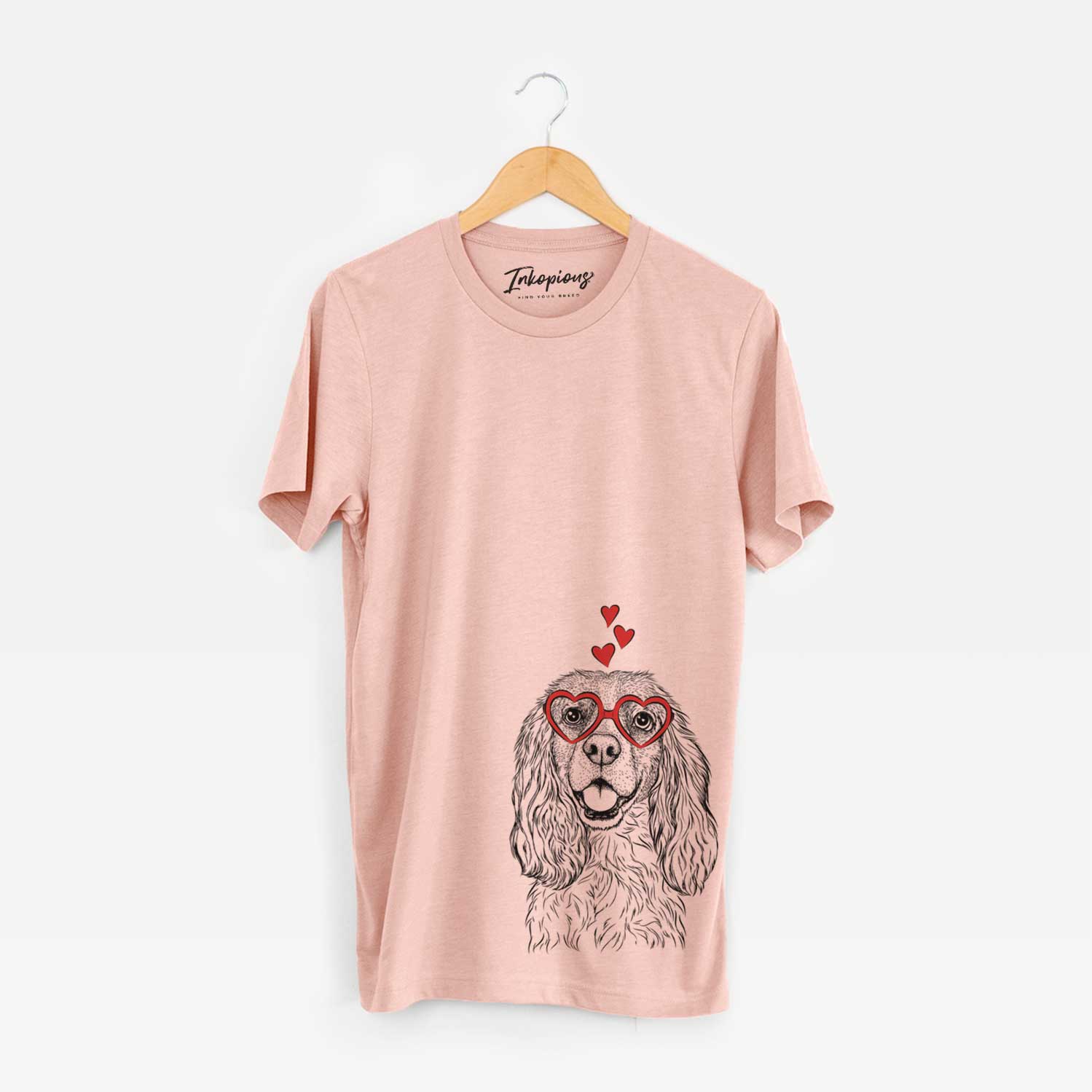 Hand-drawn sketch of Perry the Cockalier wearing heart-shaped glasses on a Peach Unisex crewneck