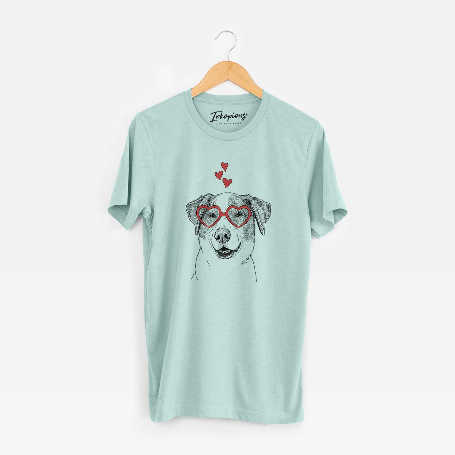 Hand-drawn sketch of Piper Pilot the Hound Mix wearing heart-shaped glasses on a Heather Sage Unisex crewneck