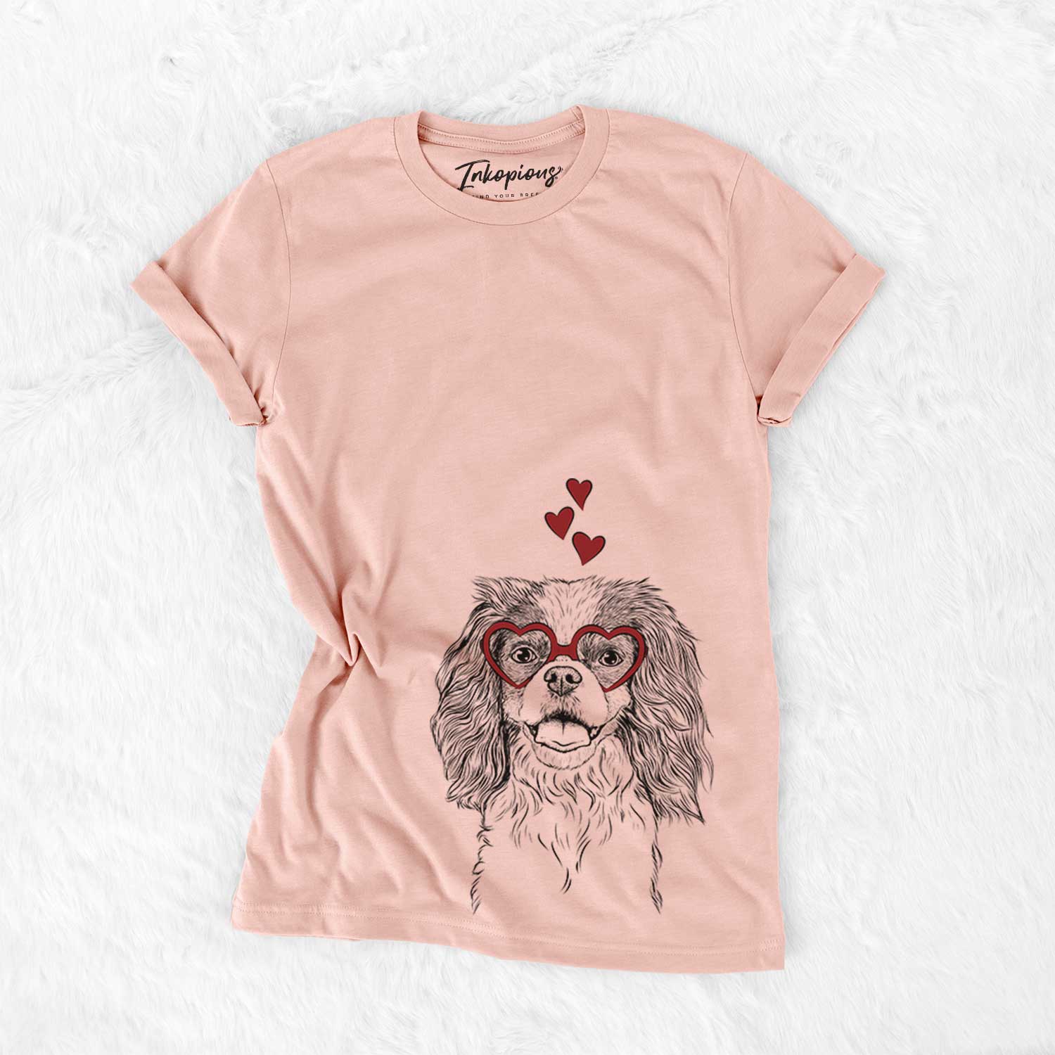 Hand-drawn sketch of Poppy the Cavalier King Charles Spaniel wearing heart-shaped glasses on a Peach Bella Canvas Unisex Crewneck