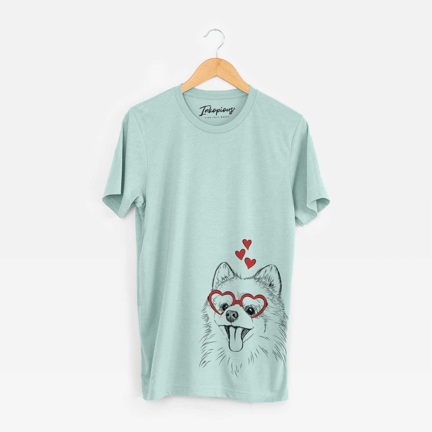 Hand-drawn sketch of Quinn the Pomeranian wearing heart-shaped glasses on a Heather Sage Unisex crewneck