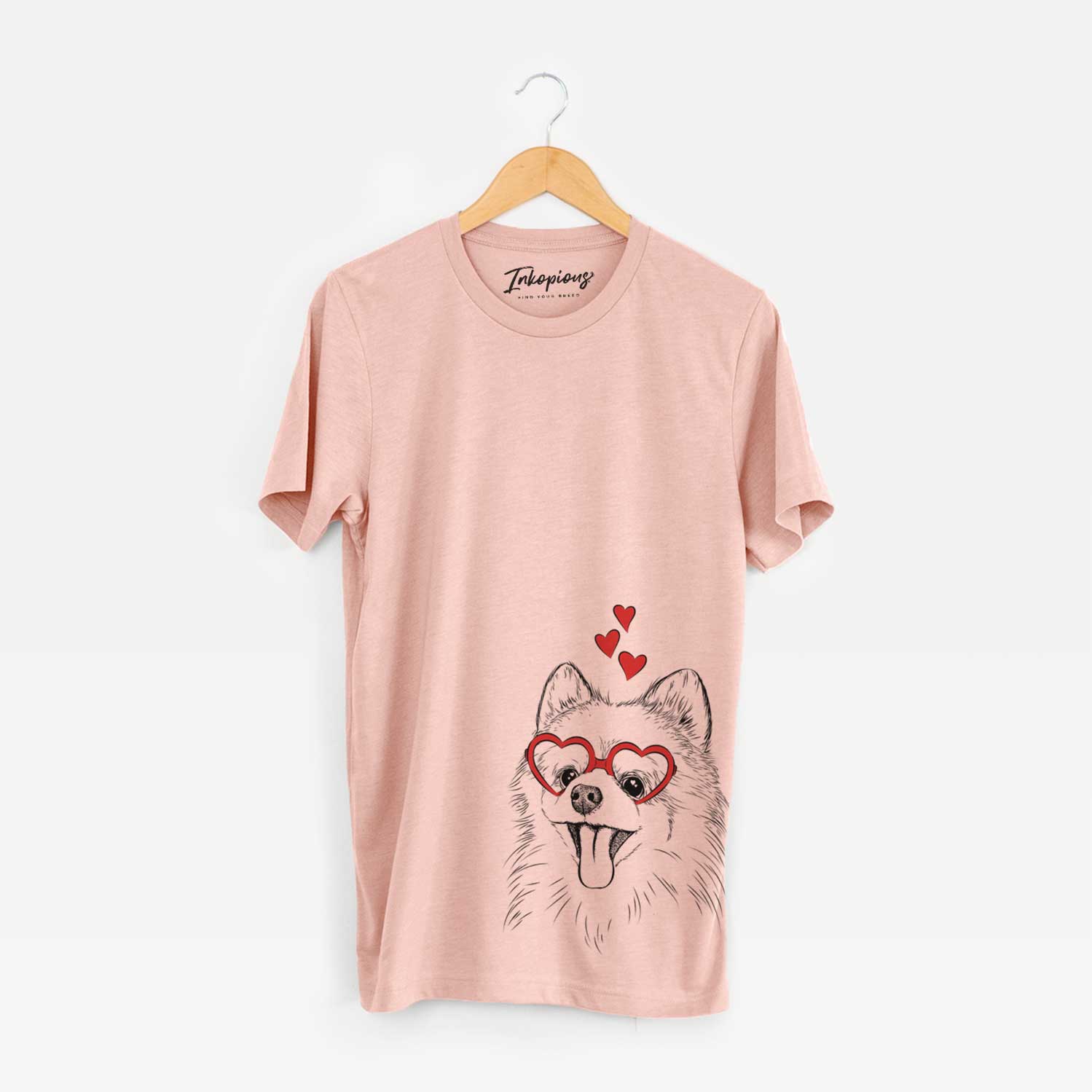 Hand-drawn sketch of Quinn the Pomeranian wearing heart-shaped glasses on a Peach Unisex crewneck