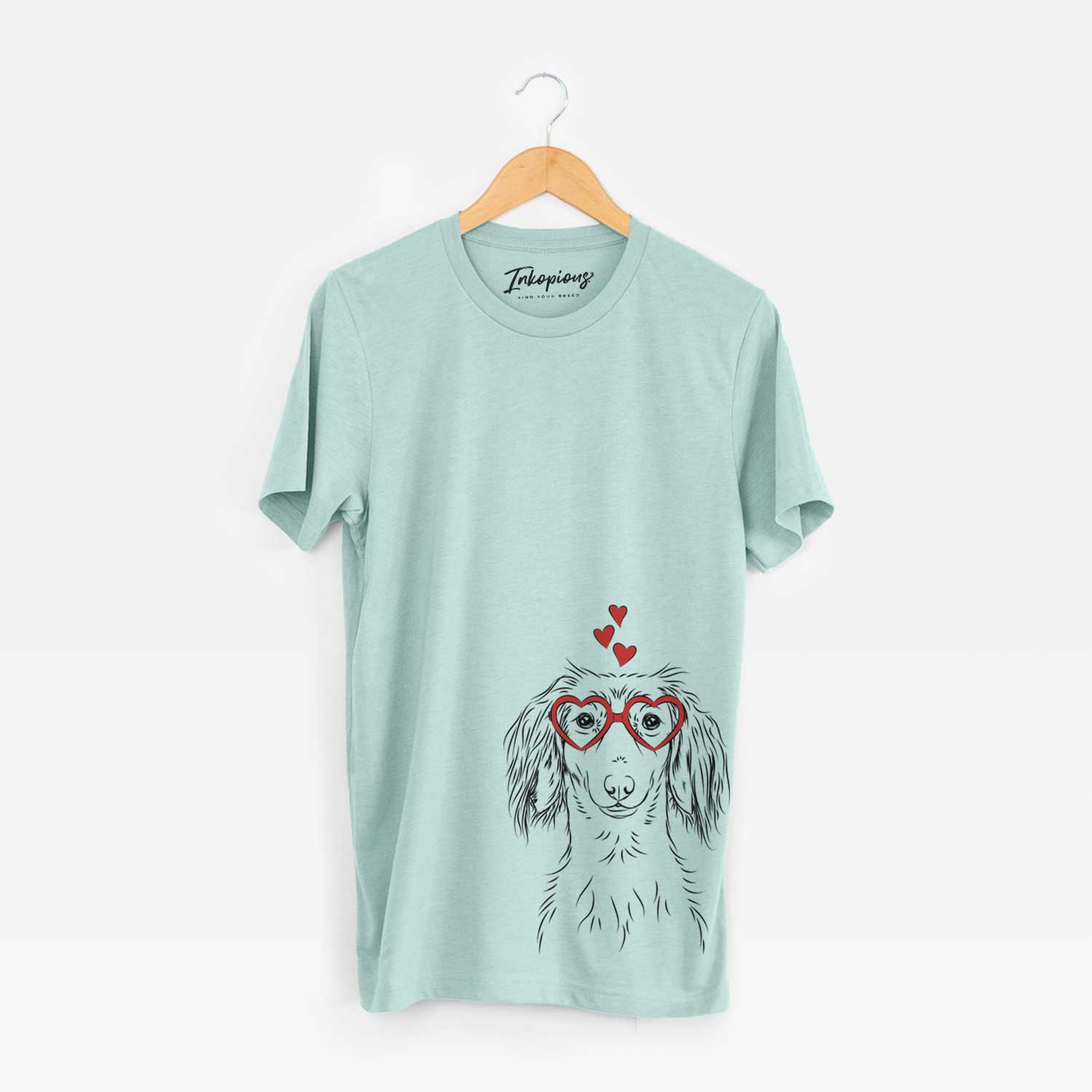 Hand-drawn sketch of Roux the Long Haired Dachshund wearing heart-shaped glasses on a Heather Sage Unisex crewneck