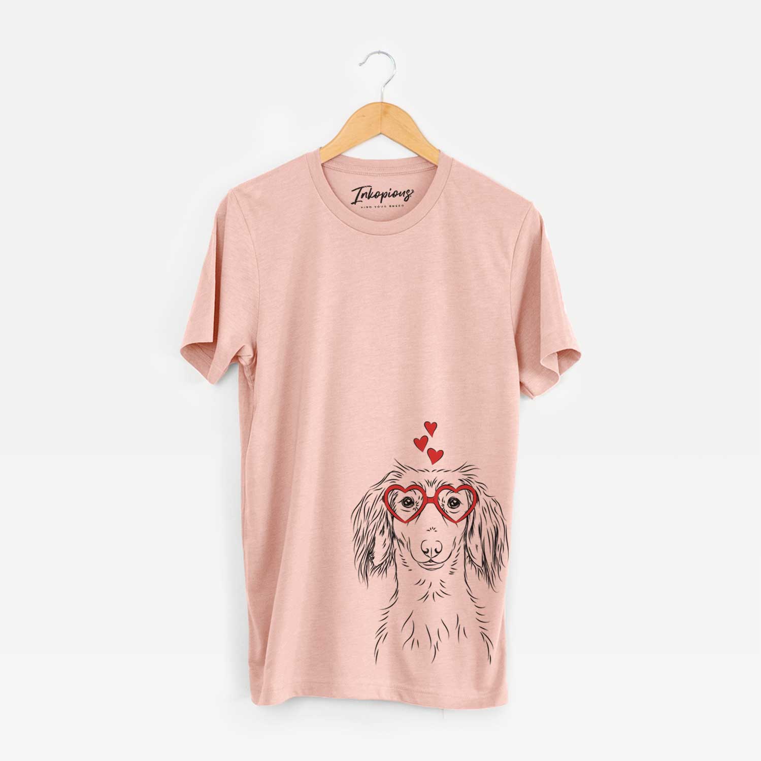 Hand-drawn sketch of Roux the Long Haired Dachshund wearing heart-shaped glasses on a Peach Unisex crewneck