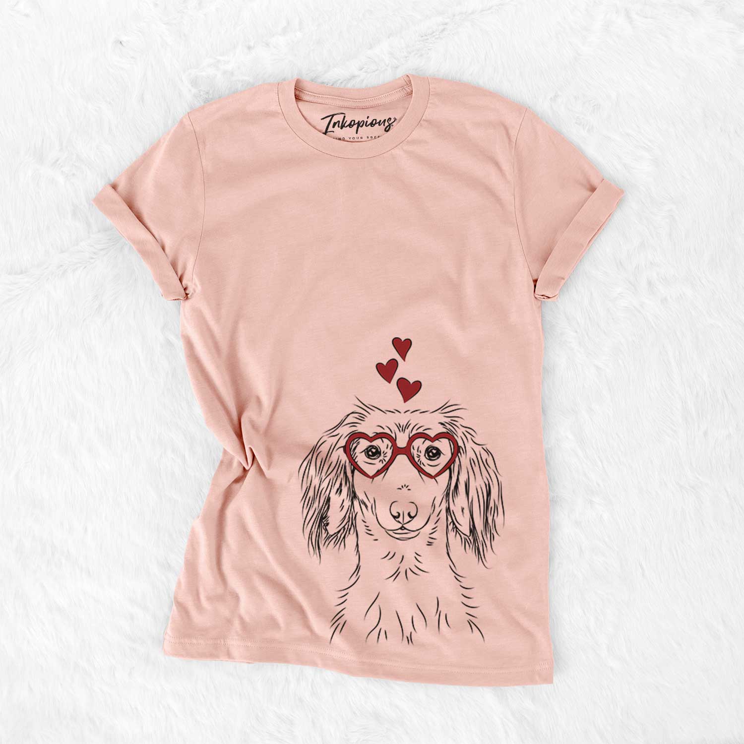 Hand-drawn sketch of Roux the Long Haired Dachshund wearing heart-shaped glasses on a Peach Bella Canvas Unisex Crewneck