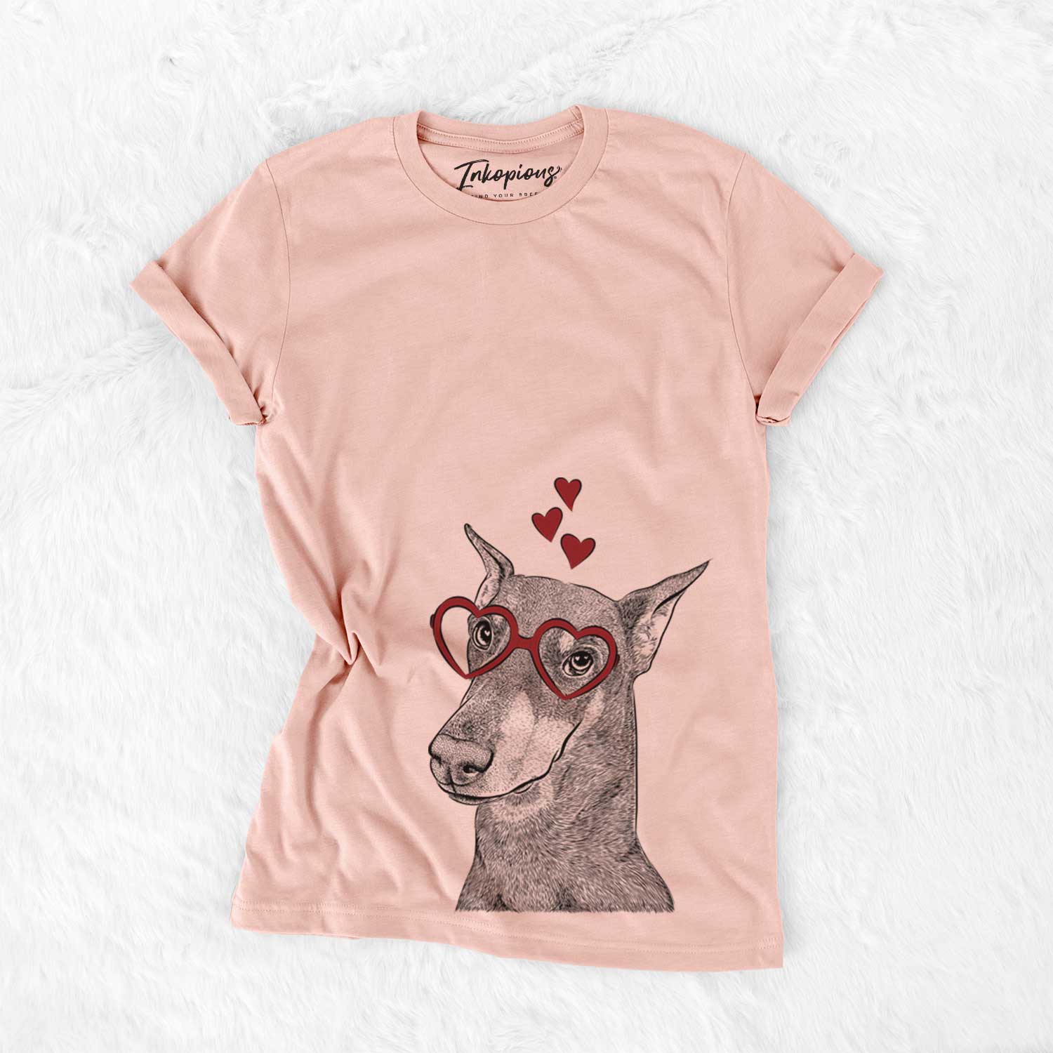 Hand-drawn sketch of Shelby the Doberman Pinscher wearing heart-shaped glasses on a Peach Bella Canvas Unisex Crewneck
