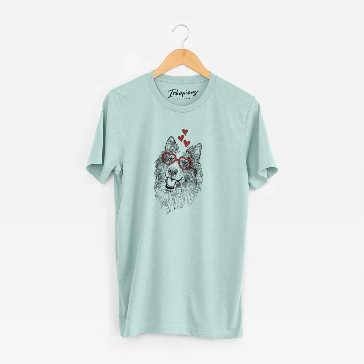 Hand-drawn sketch of Skylar the Shetland Sheepdog wearing heart-shaped glasses on a Heather Sage Unisex crewneck